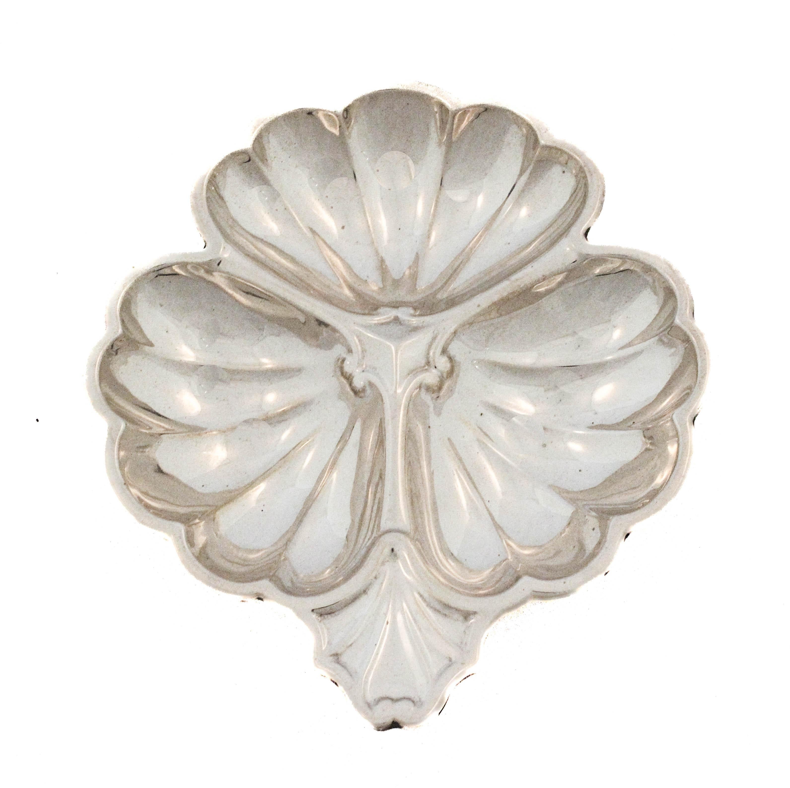 Una coppia di piatti vintage in argento sterling disegnati a forma di foglie stilizzate. Ogni piatto è diviso in tre lobi o sezioni, che si irradiano da un punto centrale e sono scolpiti con una profonda scanalatura smerlata che crea una texture