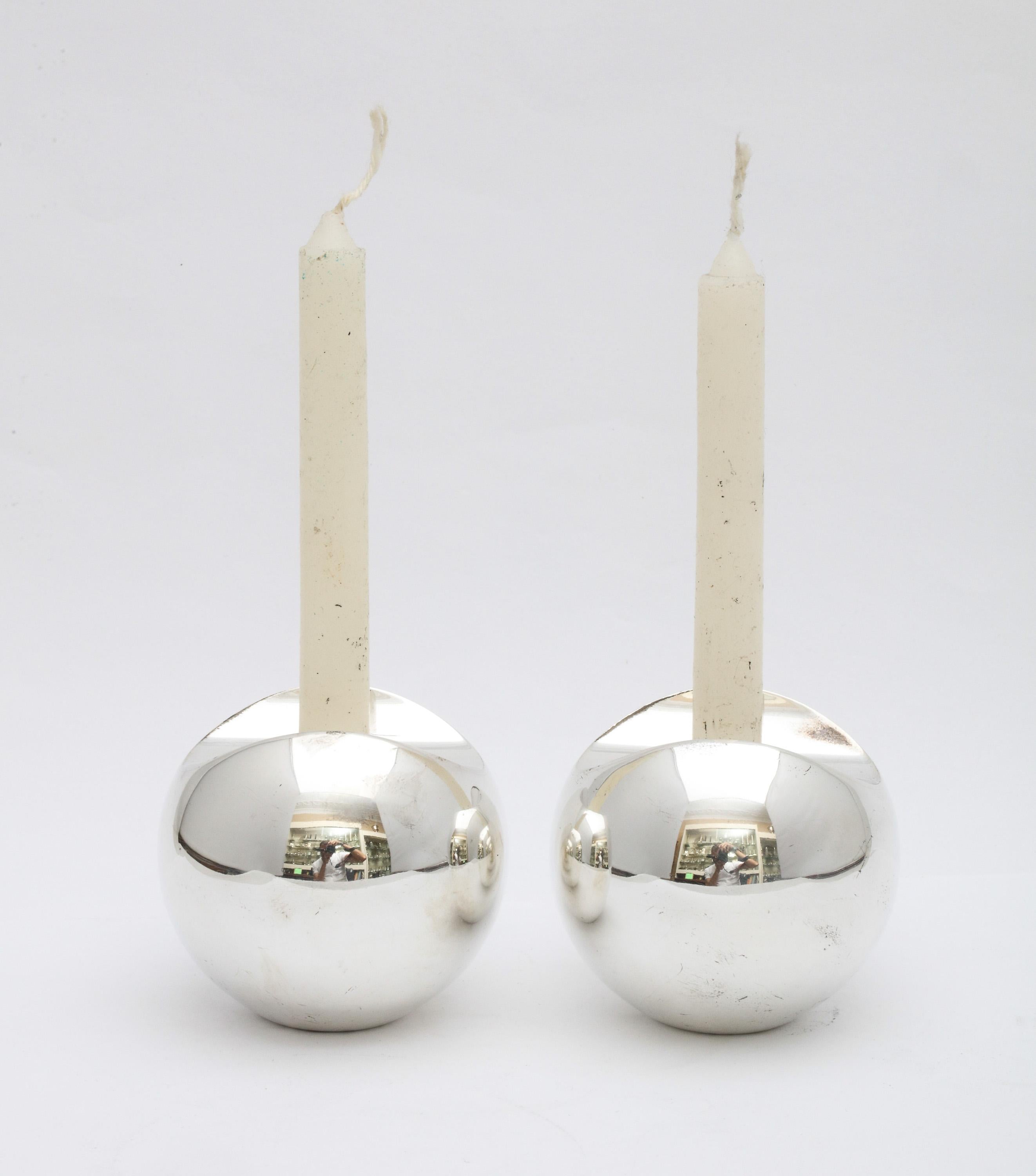 Pair of Mid-Century Modern, sterling silver candlesticks, hallmarked for Stockholm, Sweden, circa 1950s, Timo Sarpeneva, maker. Each candlestick measures 2 1/4 inches high x 2 1/2 inches diameter. Weighted. Dark spots in photos are reflections.