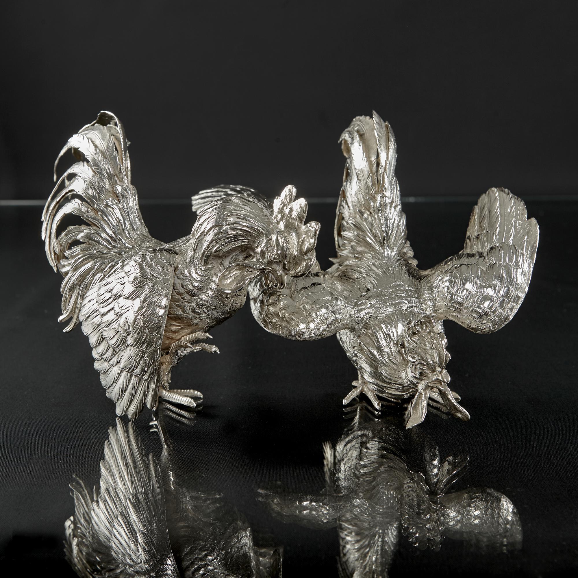 Pair of heavy quality cast silver cockerels in the traditional fighting pose. They are wonderfully modelled with a high attention to detail giving a lively and lifelike appearance. The tail feathers are individually hand cut and engraved to add an