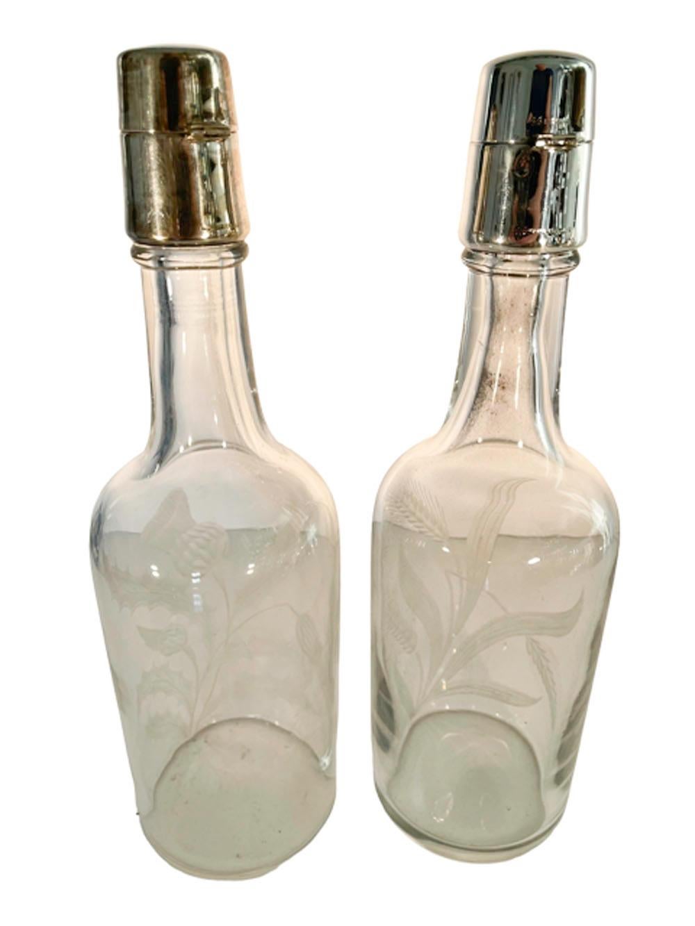 A pair of early twentieth century liquor bottles with sterling silver locking hinged caps over glass stoppers, complete with silver plate padlocks and keys, the keys have chains attaching them to their lock. The bottles are etched, one with thistles