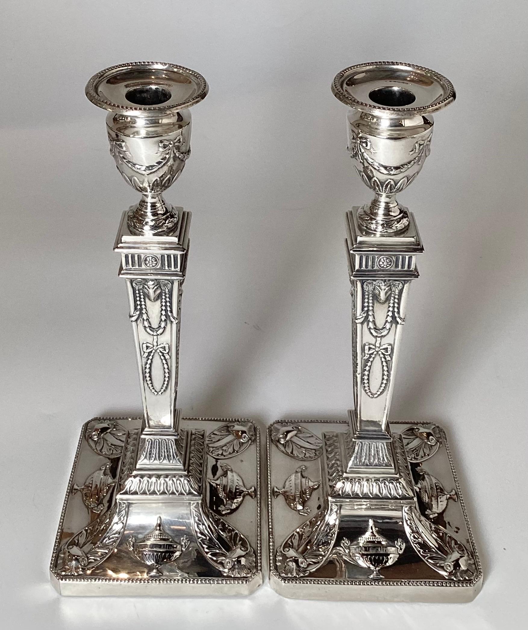 Una coppia eccezionale di  candelieri in argento sterling dal design neoclassico. 
Con motivi di urne, teste di montone e una base quadrata con dettagli ornamentali che conducono a un'alta e sottile colonna. 
 I candelieri sono alti 12 pollici con