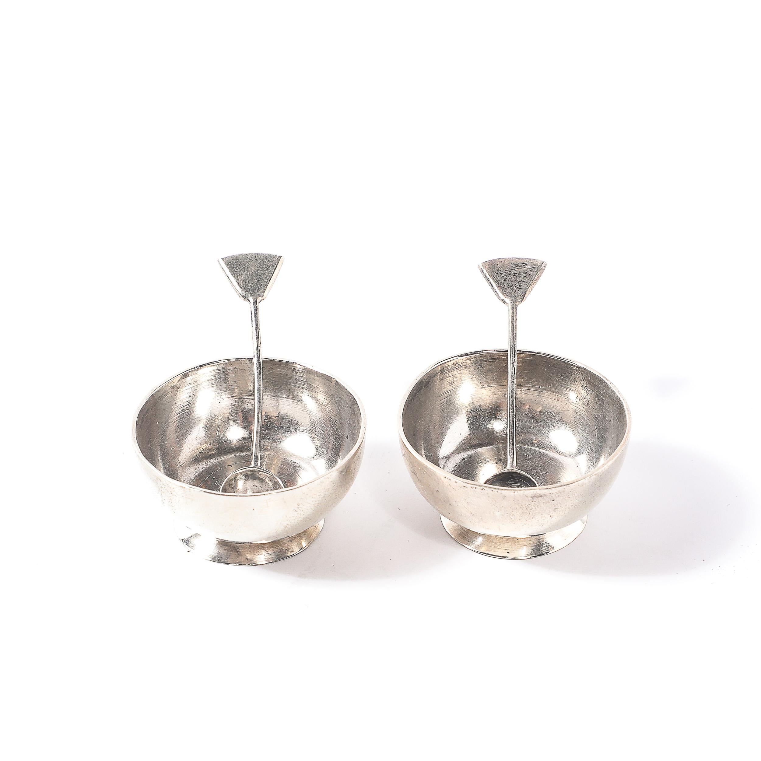 This charming pair of sterling silver salt cellars with accompanying spoons exemplifies mid-century Mexican silver artistry. Signed 