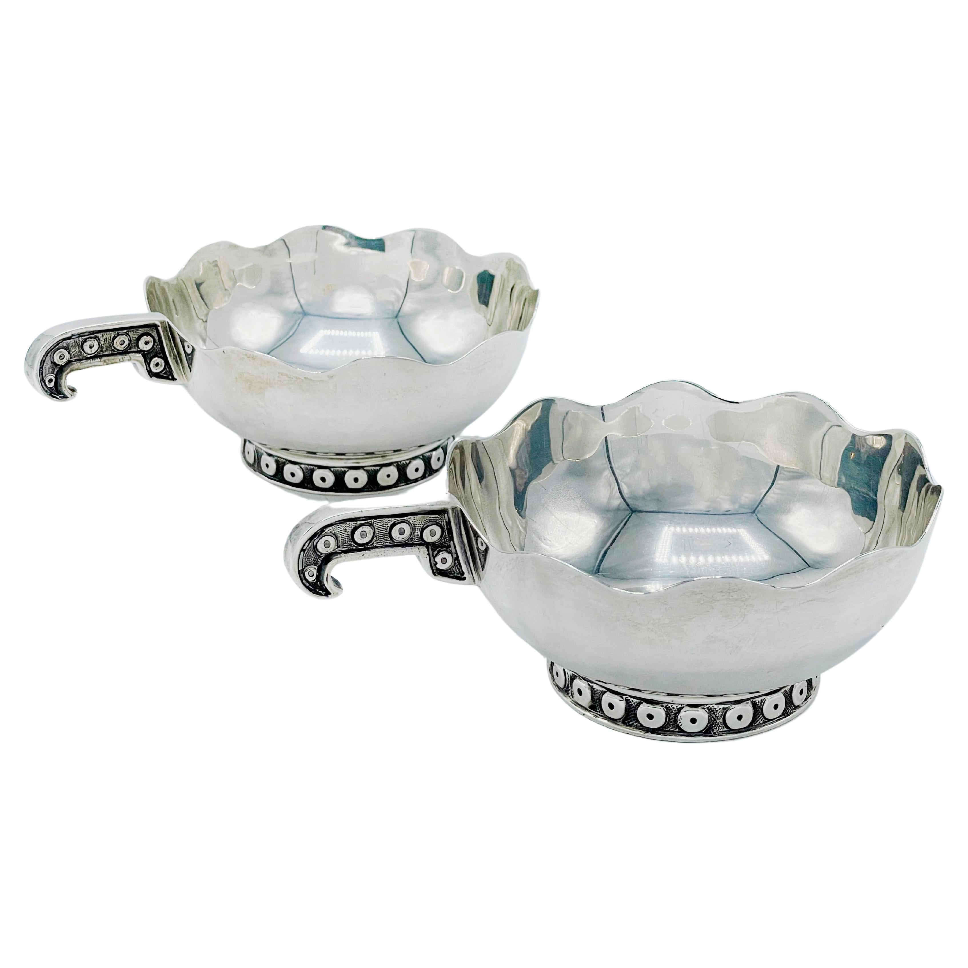 Pair of modern sauce boats with sterling silver legs and handle designed and made by Tane Orfebres in Mexico. The two open sauce boats are decorated with elements of the mythical Quetzalcoatl design on the handle and around the base.
Stamped on