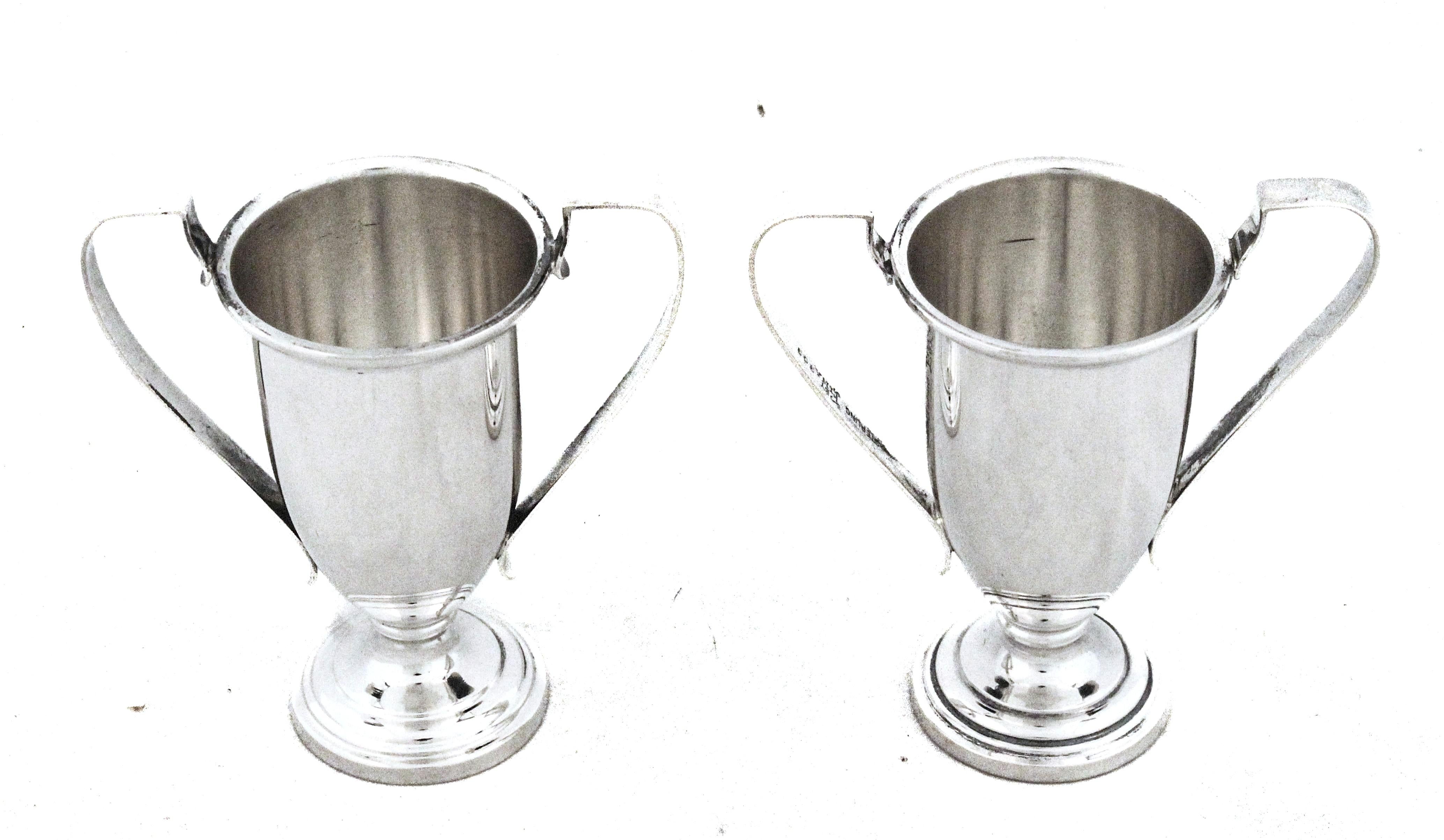 Questa elegante coppia di vasi in argento sterling è realizzata a forma di coppa d'amore, uno stile che storicamente simboleggia l'unità e la celebrazione. Ogni vaso presenta un equilibrio armonioso di proporzioni delicate e ornamenti raffinati,