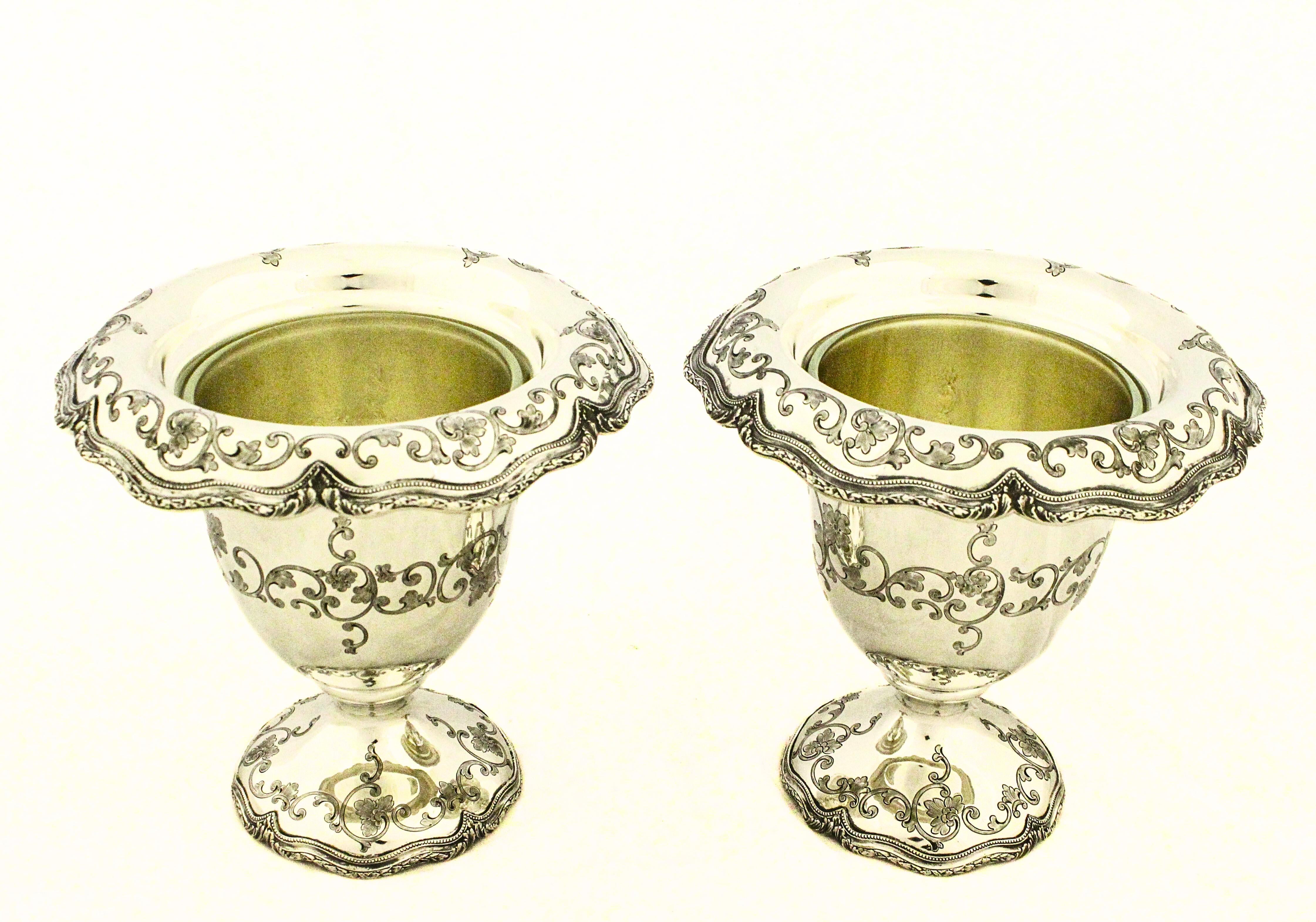 A fine pair of sterling silver urn-shaped vases crafted by Shreve & Company, San Francisco’s premier silversmiths. Each vase stands approximately 7 inches high and measures 7 inches in diameter across the scalloped rim.

The vases are of classical