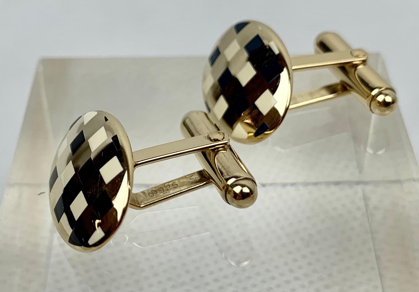 

A pair of vermeil (gold over sterling silver) oval cufflinks with squares of high fired black and white enamel.  They are marked sterling and .925 on the posts.  The posts are hinged so they can move with your shirt as your wrist bends.  Better