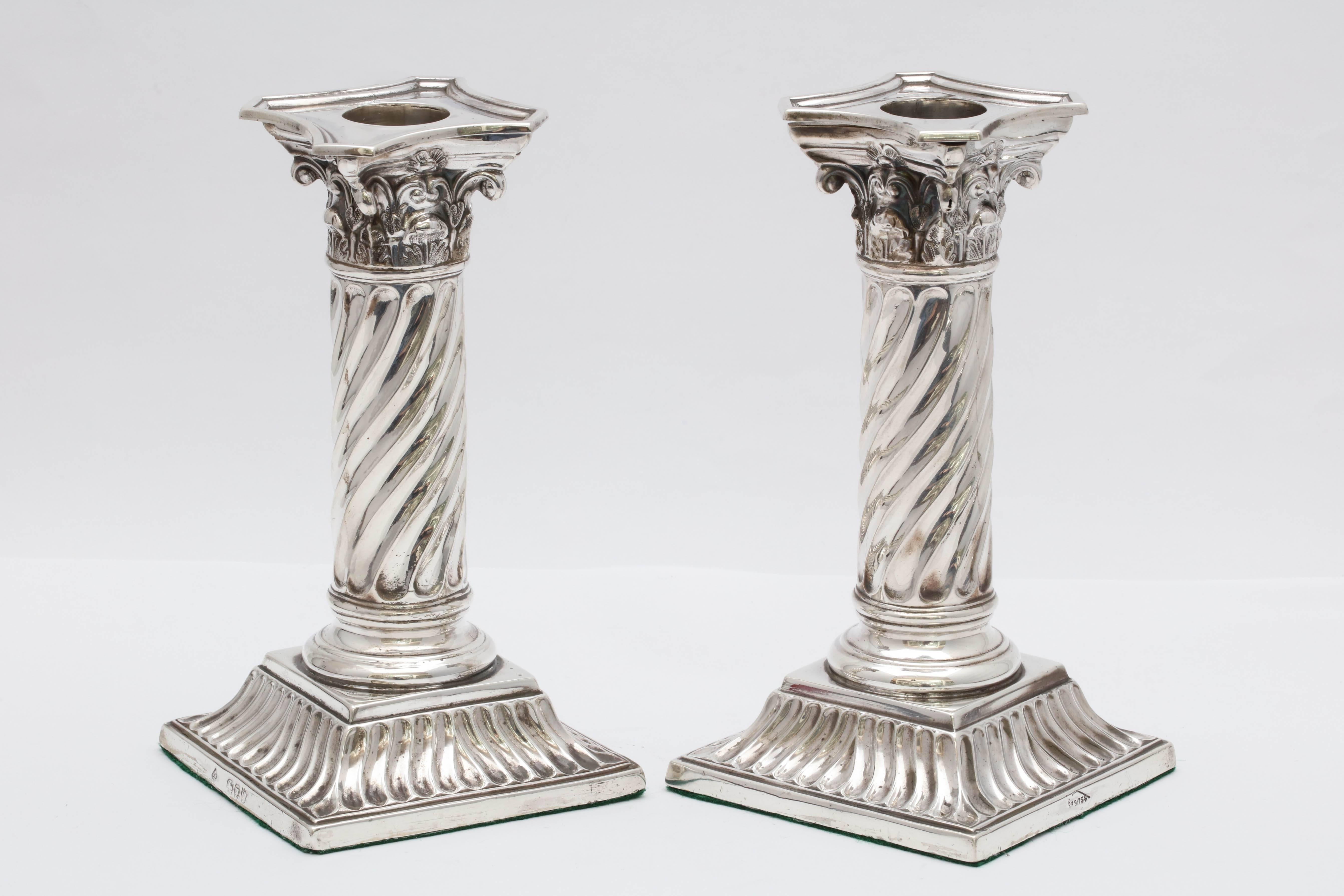 Rare, unusual pair of sterling silver,, neoclassical design, Corinthian column candlesticks, London, 1891, Martin and Hall - makers. Measures: 6 inches high x 3 1/4 inches wide x 3 1/4 inches deep. Weighted. Removable bobeches. Columns are spiral in