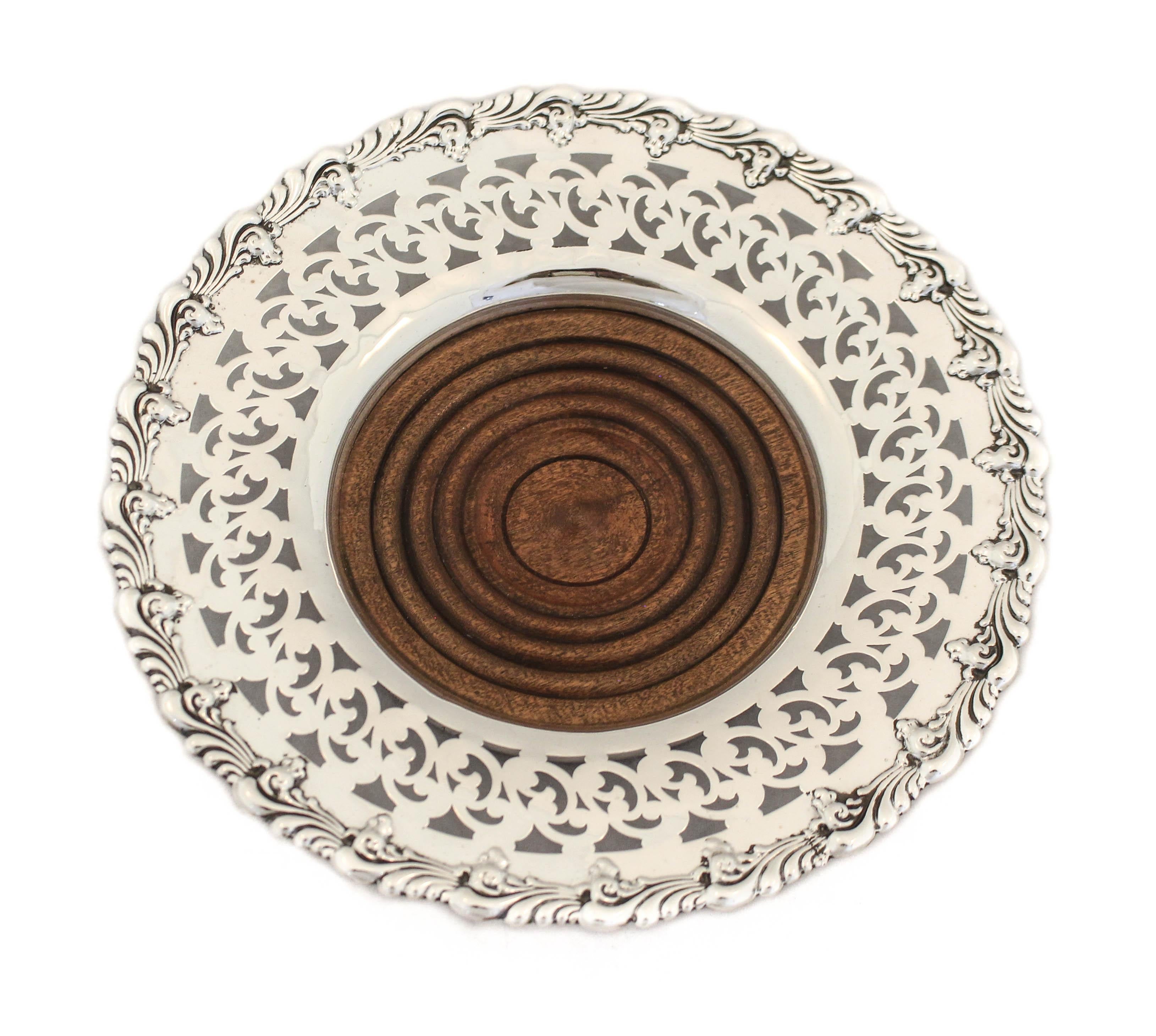 We are thrilled to offer you this pair of sterling silver wine coasters by Black Starr & Frost. They have a 2.5” sterling silver rim that has a scalloped edge and a reticulated pattern. The center is wood that is stained a dark rich brown. On the