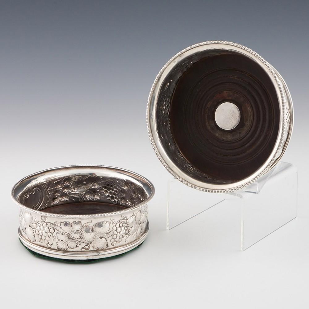 Heading : Sterling silver wine coasters
Date : Hallmarked in London in 1799 - makers mark rubbed
Period : George III
Origin : London, England
Decoration : Repousse and chased vine leaf decoration, turned wood base, pie crust rim
Size :  13.8cm
