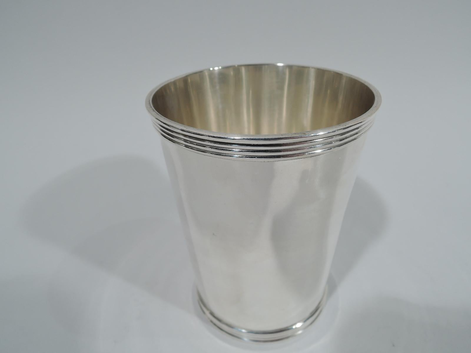 Pair of traditional sterling silver mint julep cups. Made by Stieff in Baltimore. Straight and tapering sides, and reeded rim and base. Fully marked and numbered 0701Y. Total weight: 8.5 troy ounces.