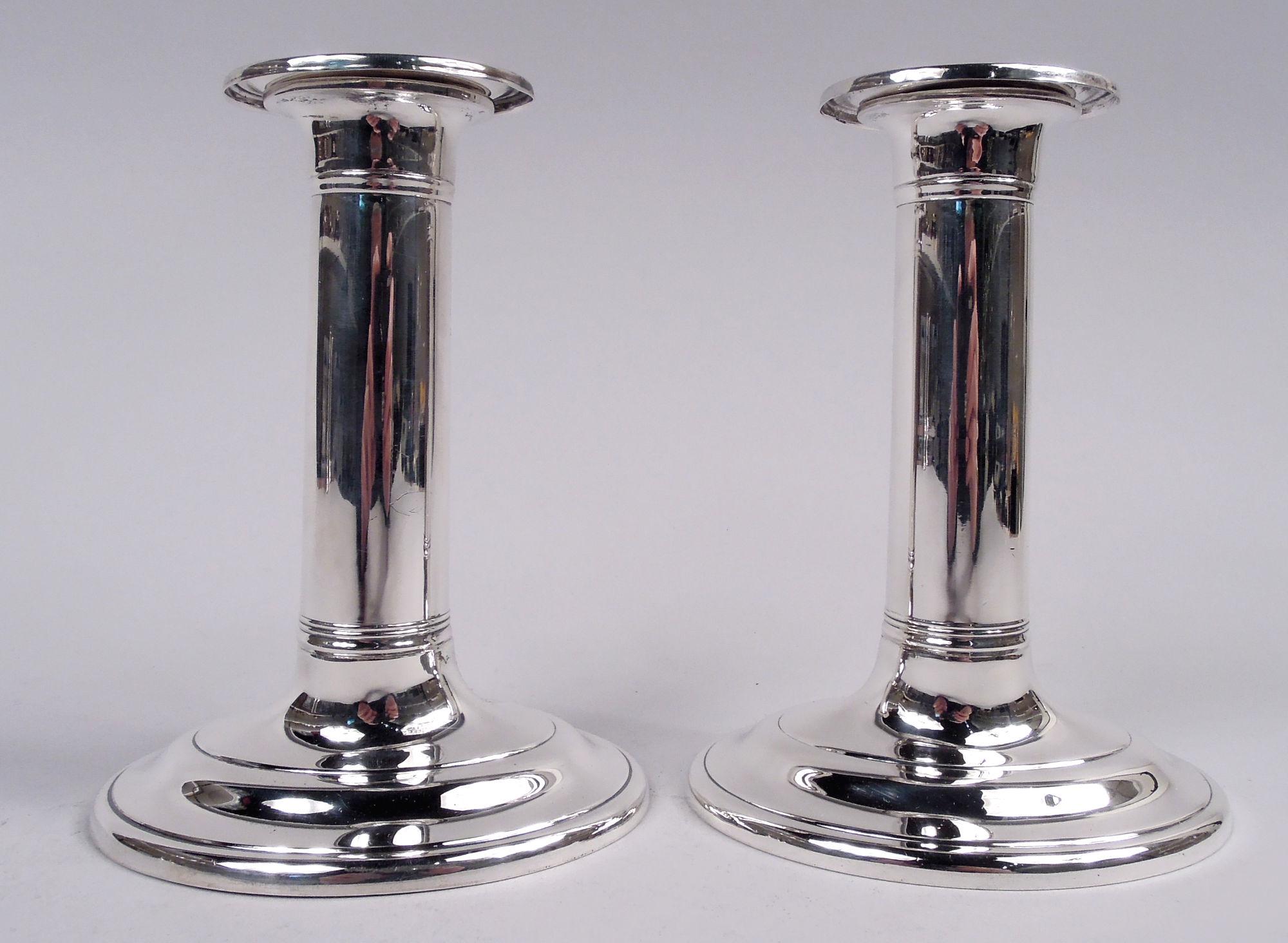 Coppia di candelieri in argento Williamsburg. Realizzato da Stieff a Baltimora, circa 1950. Ciascuno: Fusto colonnare con bande incise e bobeche staccabili; piede rialzato. Ovale. Nell'omonimo modello associato a Colonial Williamsburg. Completamente