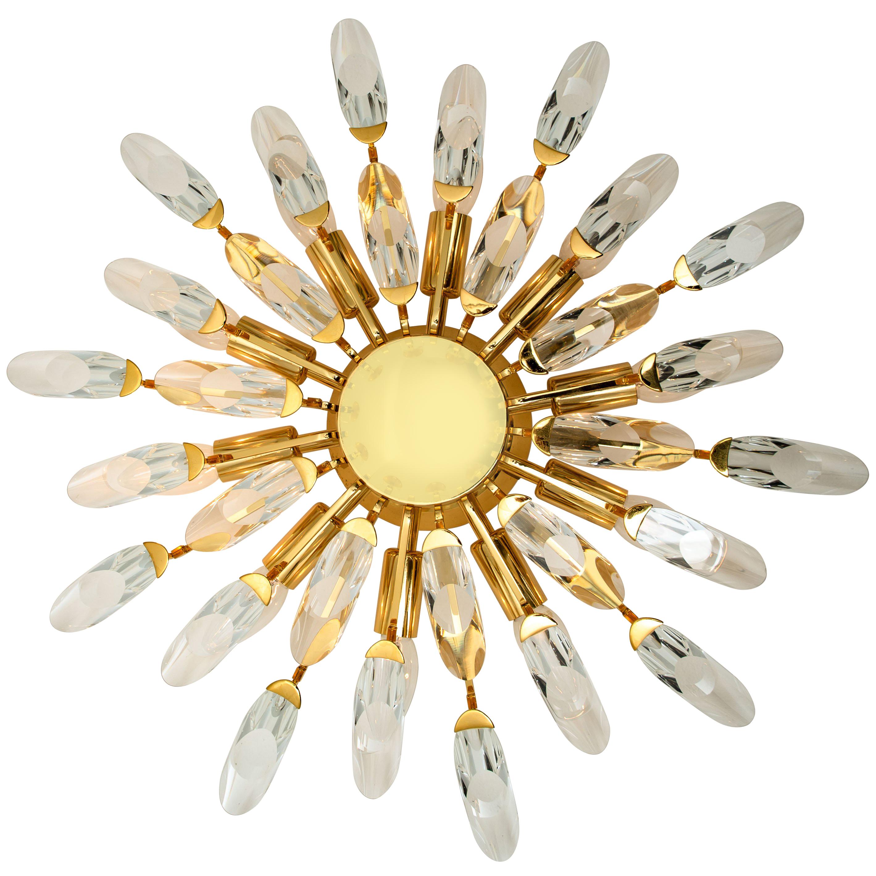 High-end gilded brass flush mounts by Stilkronen, made in Italy, circa 1975. Each fixture is featuring a sunburst array of branches holding 30 clear crystals pieces. The crystals refract light beautifully and are perfect for a soft, warm and