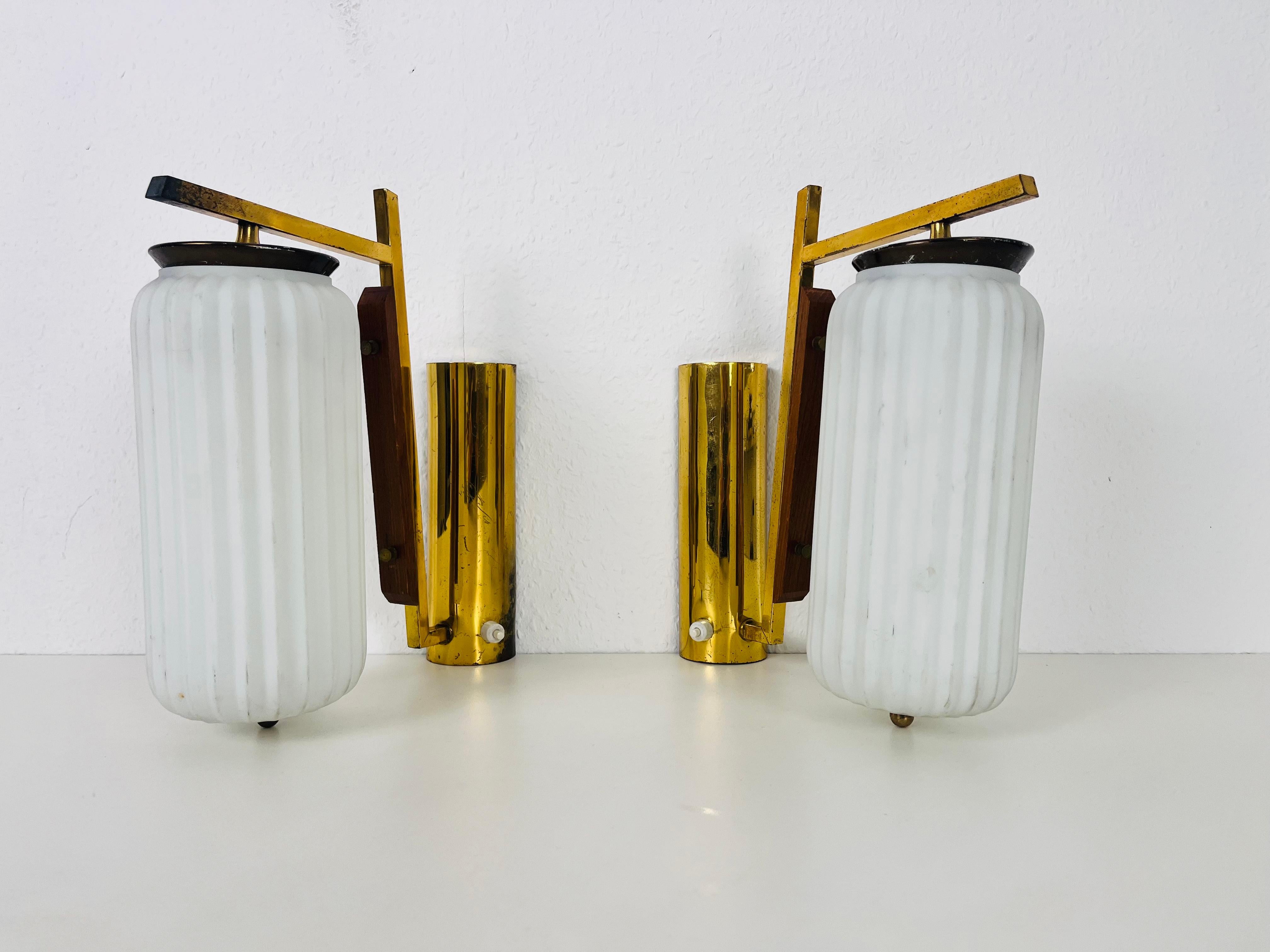 A pair of Italian Stilnovo wall lamps made in the 1960s. It is fascinating with its rare opaline glass shade. The body of the lamp is made of brass 

The lights require E14 light bulbs. Works with both 120/220V. Very good vintage