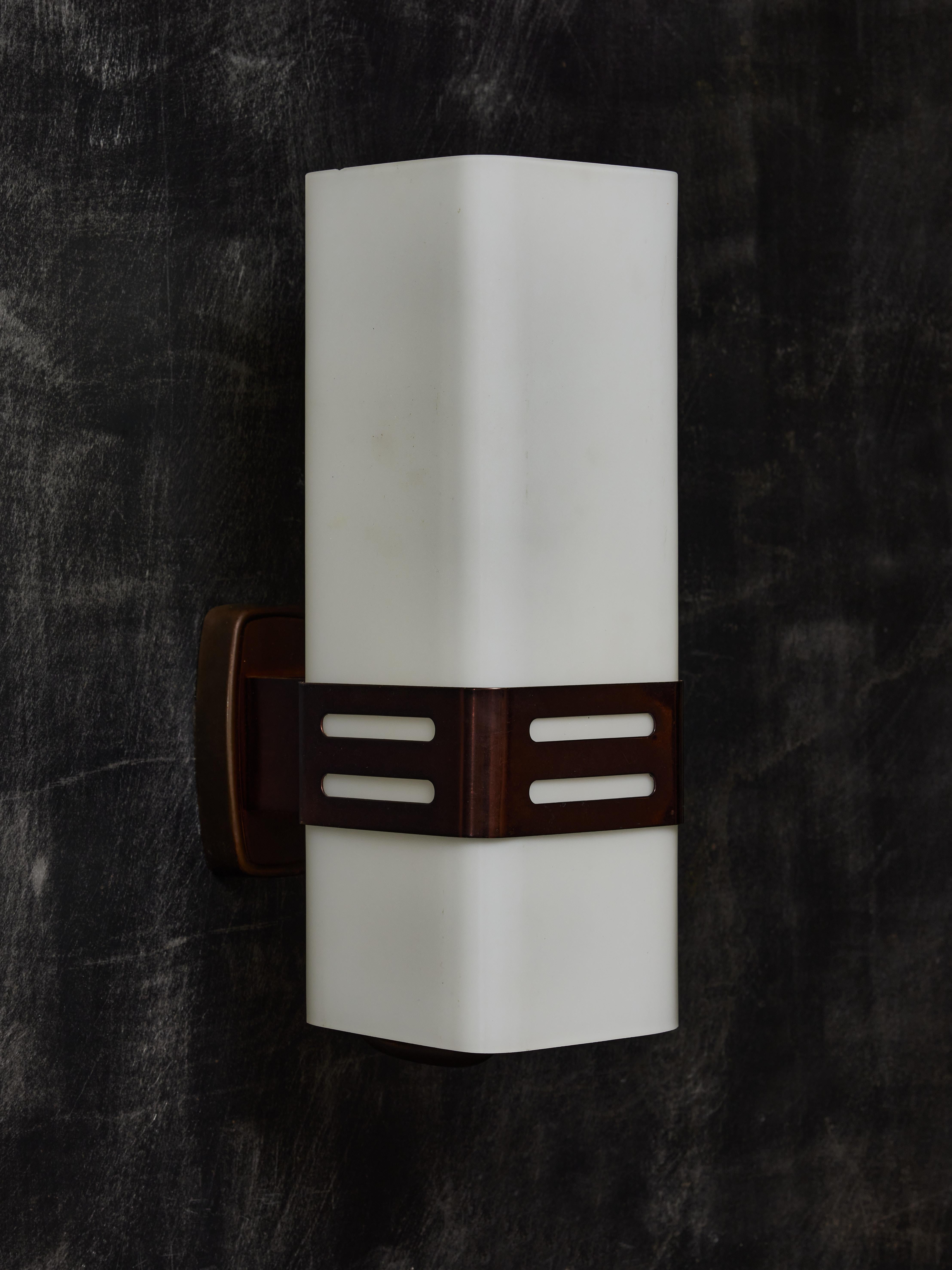 Pair of midcentury wall sconces made of a brass backplate and holder and a rectangular opaline glass diffuser. Original stamp of the manufacturer on the bases.

Stilnovo
Stilnovo is a prestigious Italian lighting manufacturer 
Founded in 1946 in