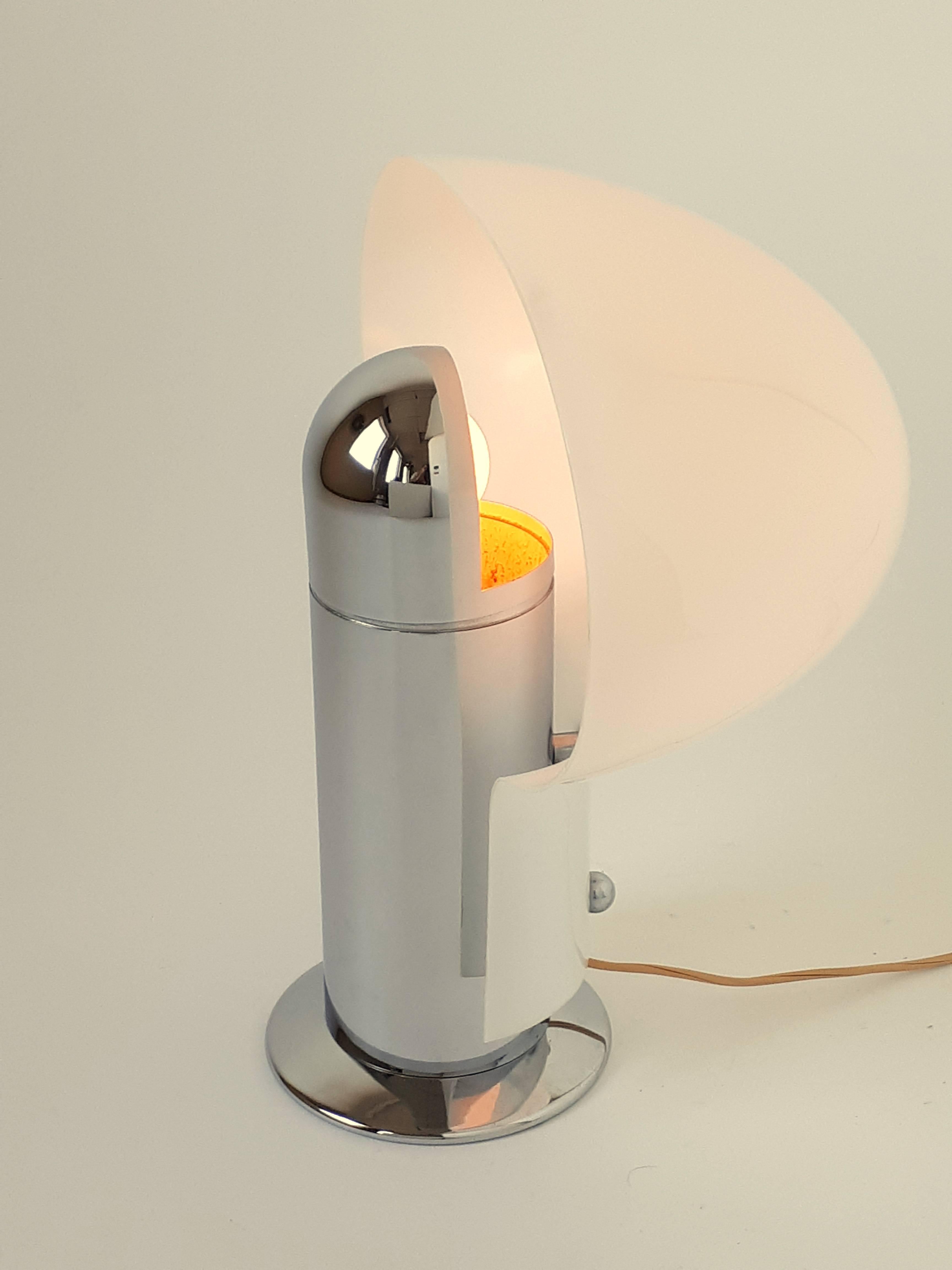 Wide opale acrylic shade sitting on a deep chrome heavy sculptural base. 

Designed by Celli Tognon in 1972 for Stilnovo. 

Original switch, cord and North American wall plug.

Contain one E26 regular size socket rated at 60 watts max.