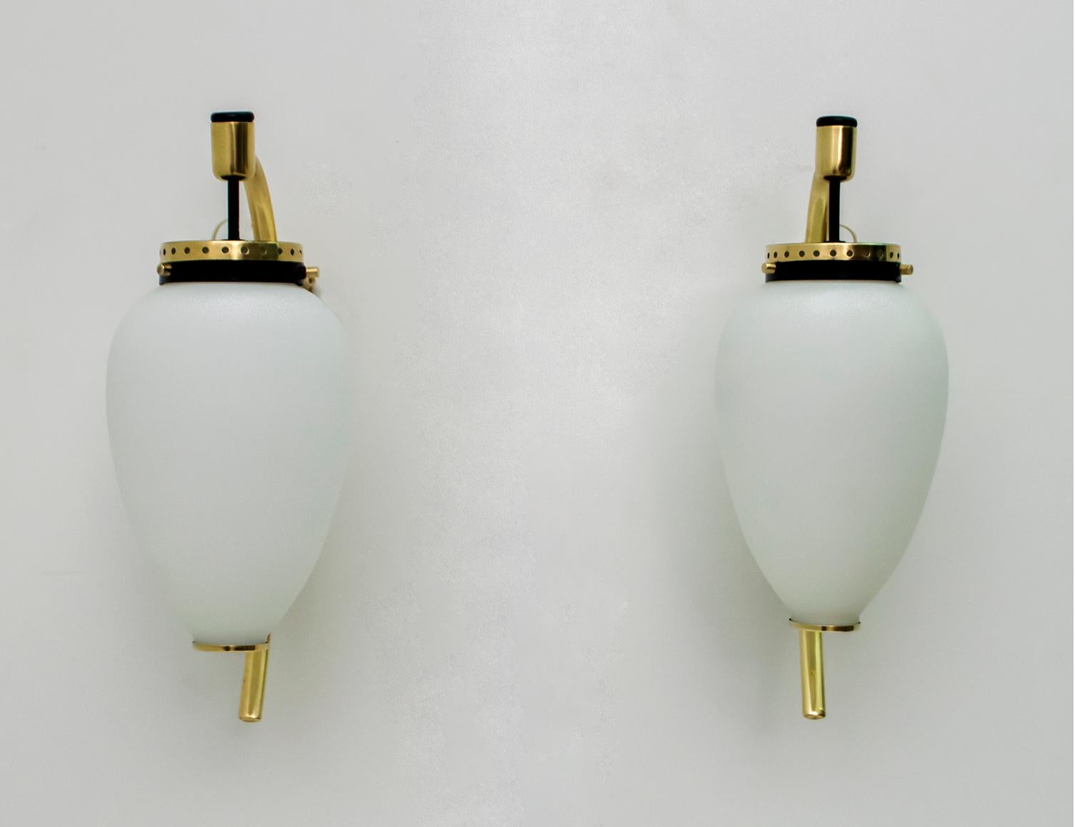 Pair of sconces in polished brass, black lacquered metal and opal glass. Produced by Stilnovo in Italy in the 1950s.
The sconces have been completely restored and polished.

       