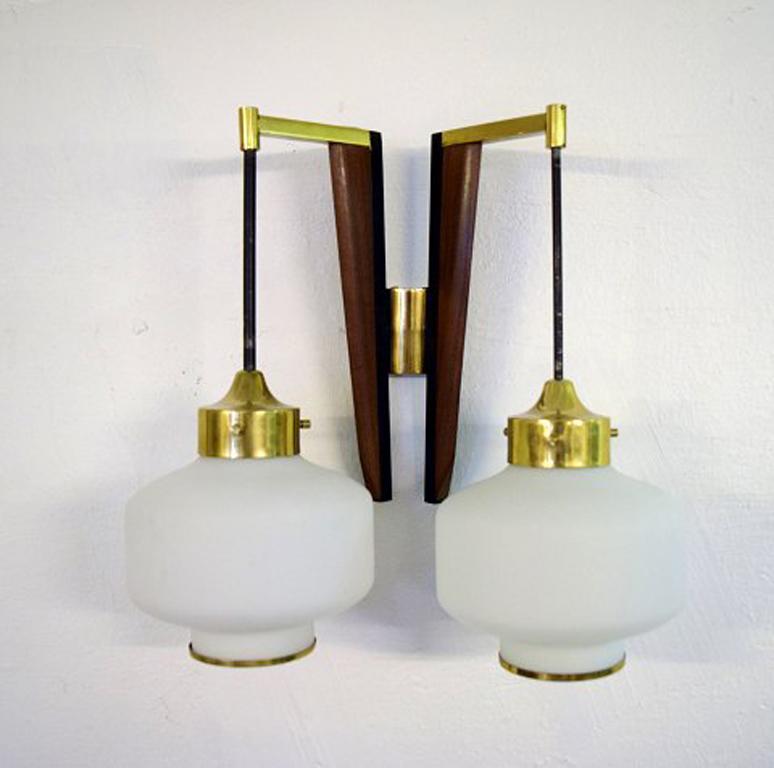 A pair of Stilnovo modernist wall lamps in teak and brass. Opal glass.
Italy, 1950s.
In excellent condition.
Measures: 35 cm x 35 cm.