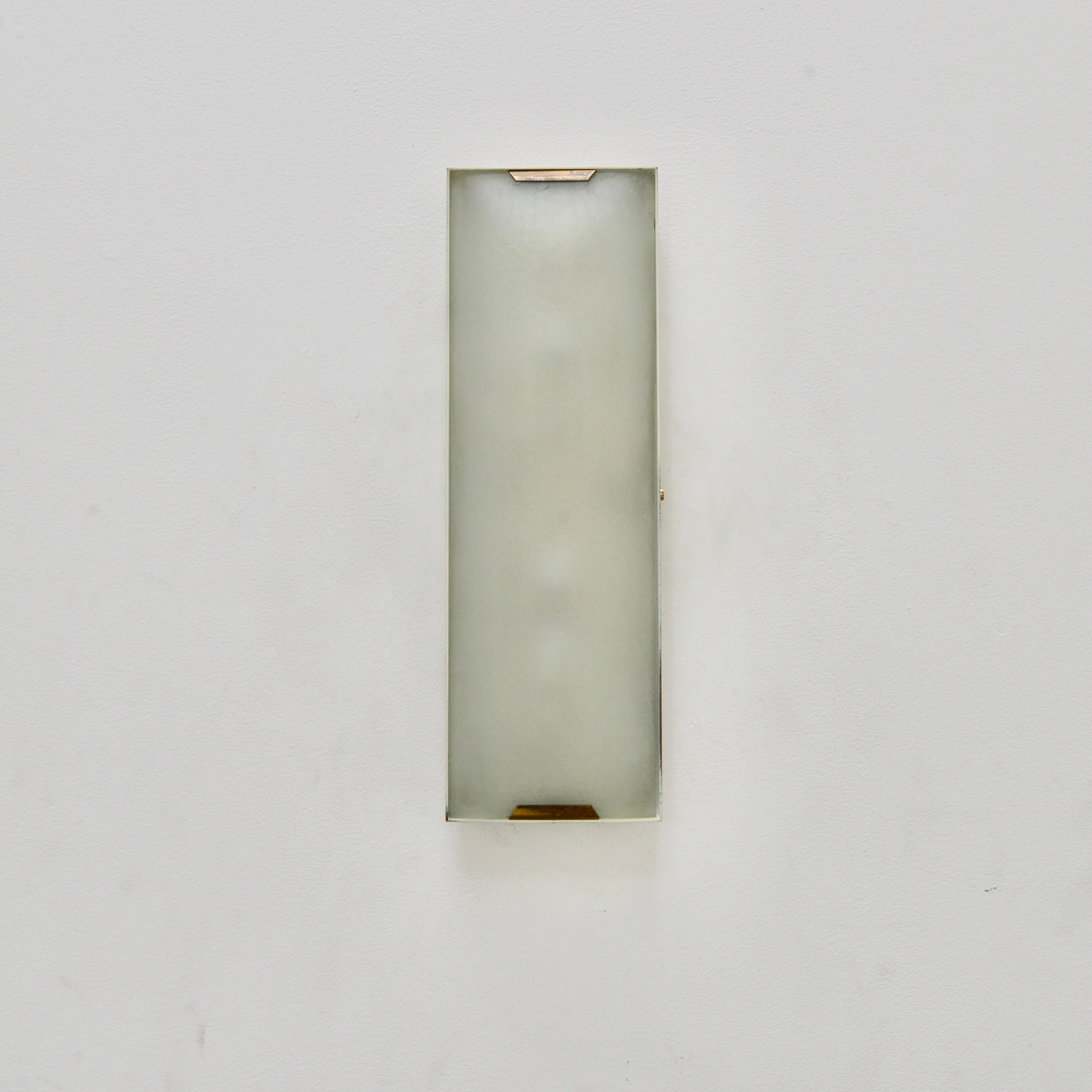 Fantastic 1950s pair of Stilnovo wall lights from Italy. These rectangular sconces are made from steel, naturally aged brass and incredible vintage Italian textured glass. They are rewired for use in the US with a (3) E12 candelabra based socket per