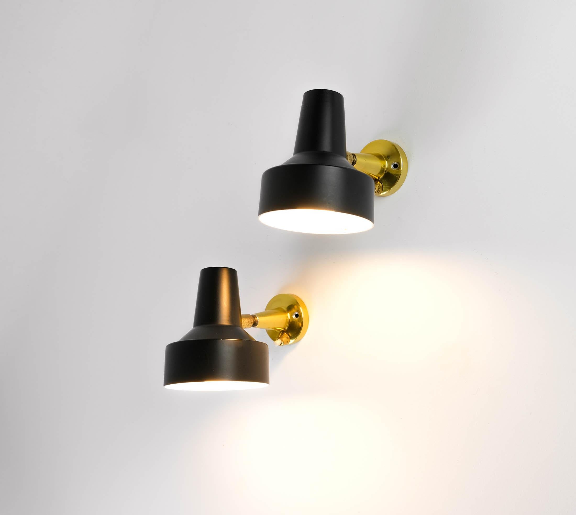 For sale a stylish and very rare pair of Mid-Century Modernist Stilux Milano small articulated wall spot lights/sconces, produced in Italy, circa 1950s.

Each light consists of a matt black metal shade, with matt white on the inside, mounted on a