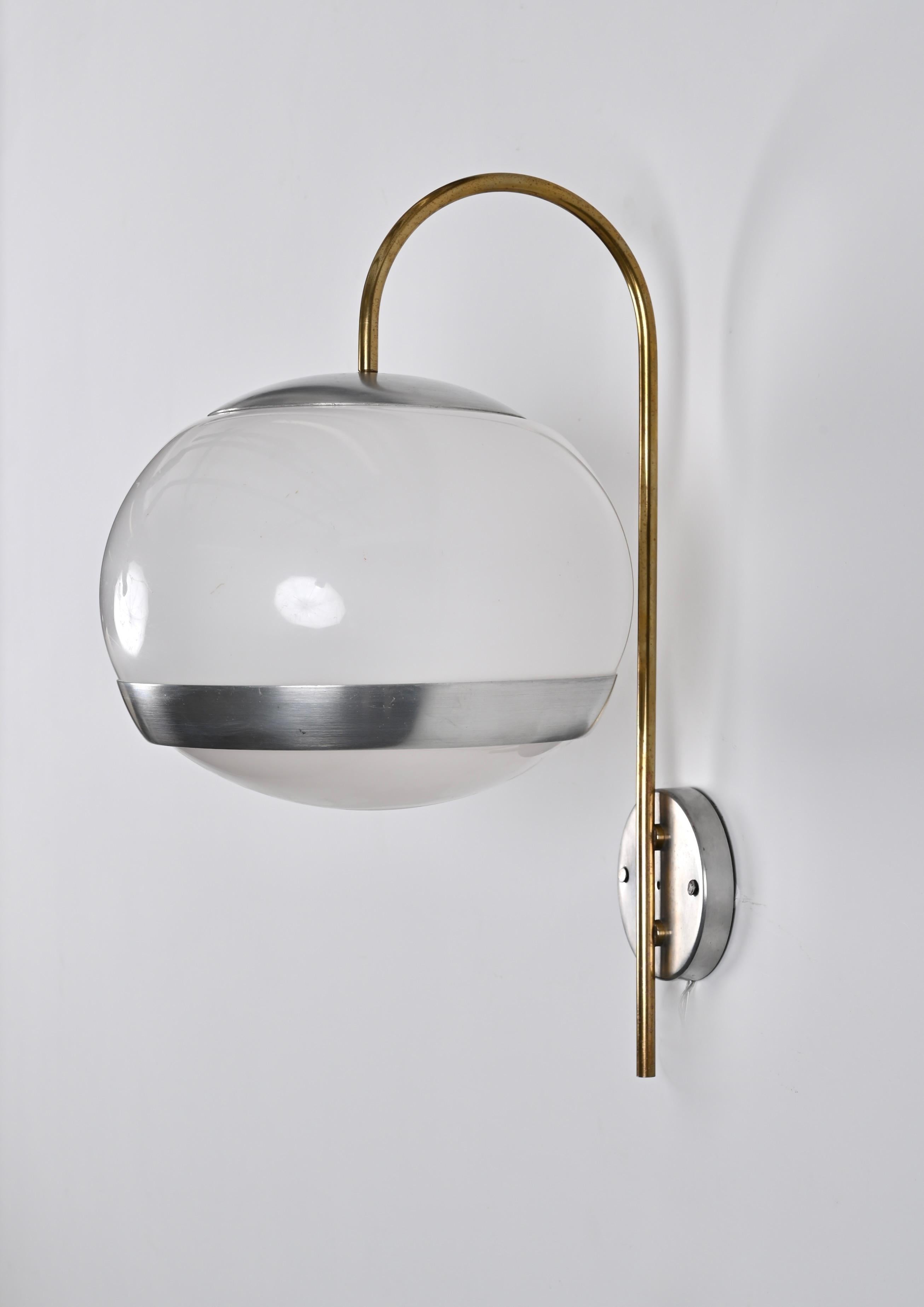 Wonderful pair of mid-century sconces in white white perspex, aluminum and brass, produced by Stilux in the 70s in Italy.

These beautiful wall lamps feature an elegant curved hook in brass that connects to a light ball in white plexiglass and