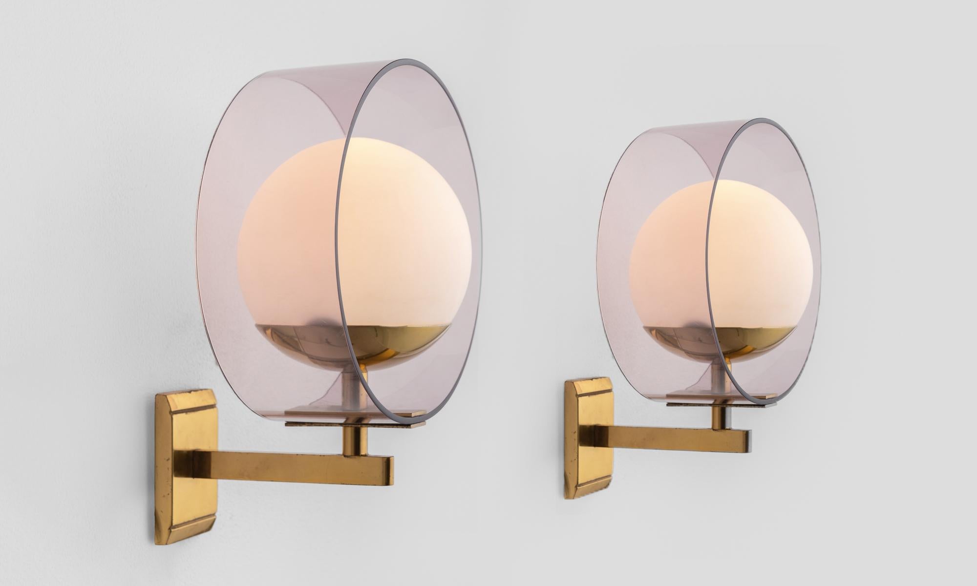 Pair of Stilux wall lights, circa 1960.

Frosted globes on brass hardware are surrounded by a tinted plexiglass cylindrical form.