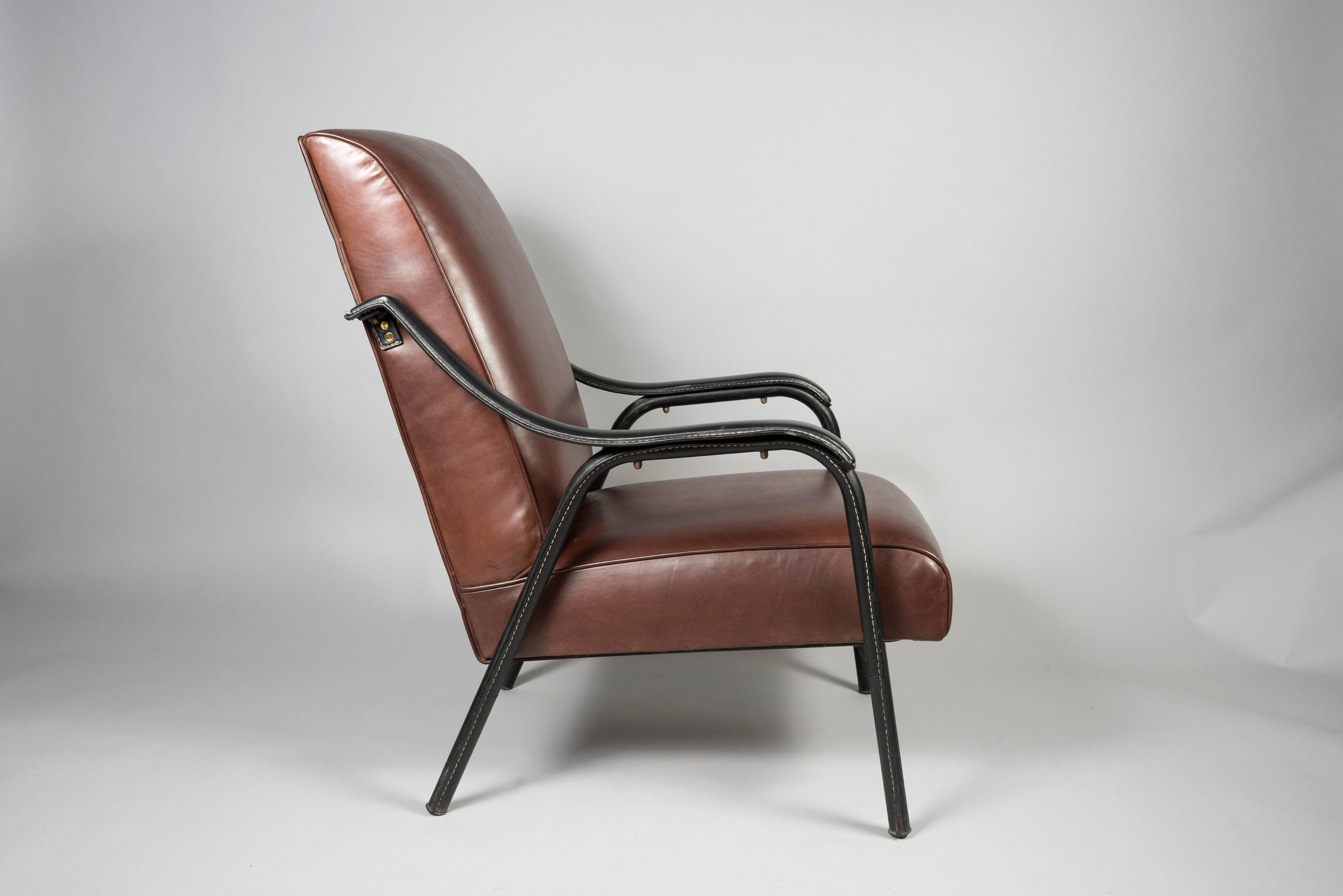 Pair of 1950's Stitched leather armchairs by Jacques Adnet
Feet and arms are stitched with original faux leather
France.