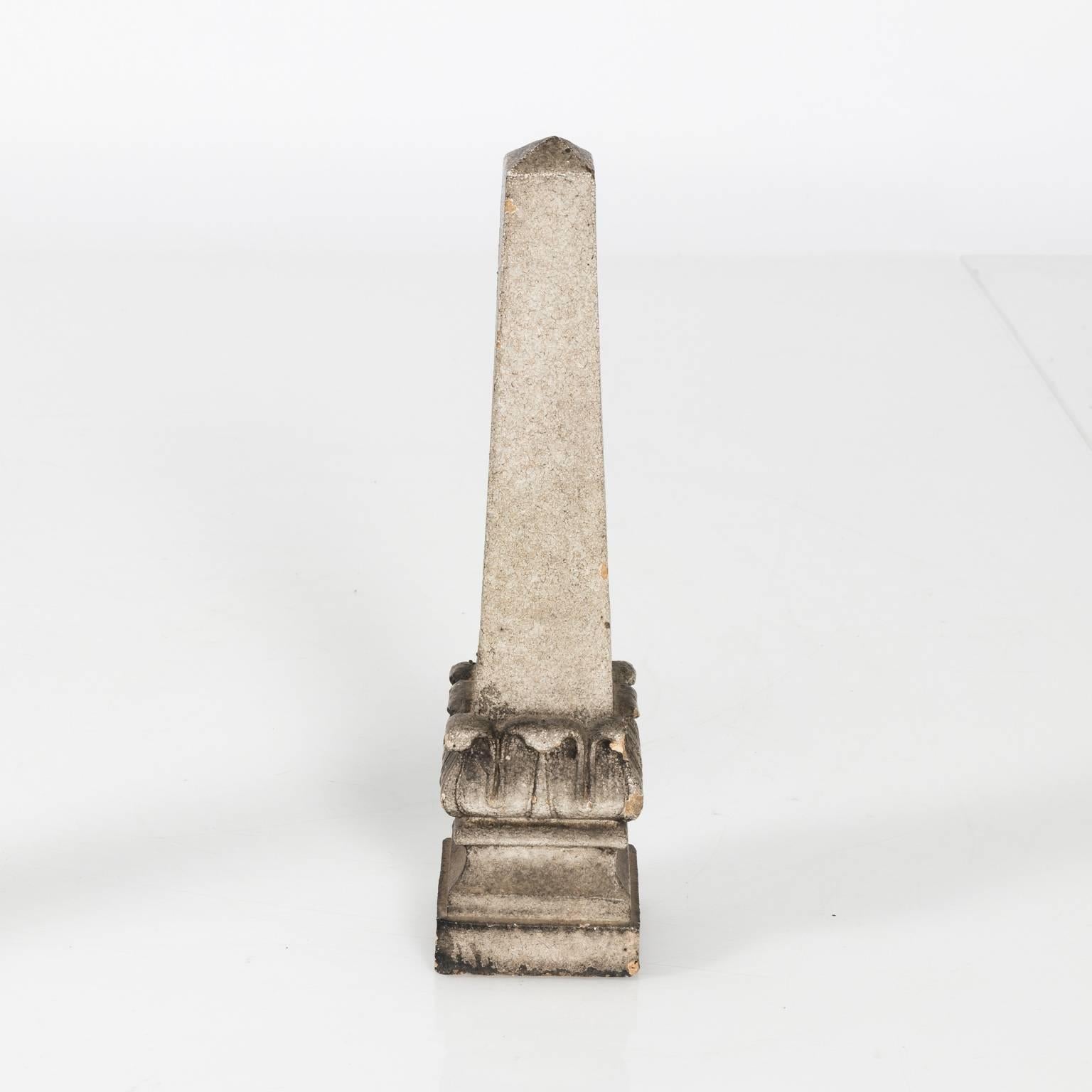 Contemporary pair of decorative cut stone obelisks with acanthus leaf bases.
 