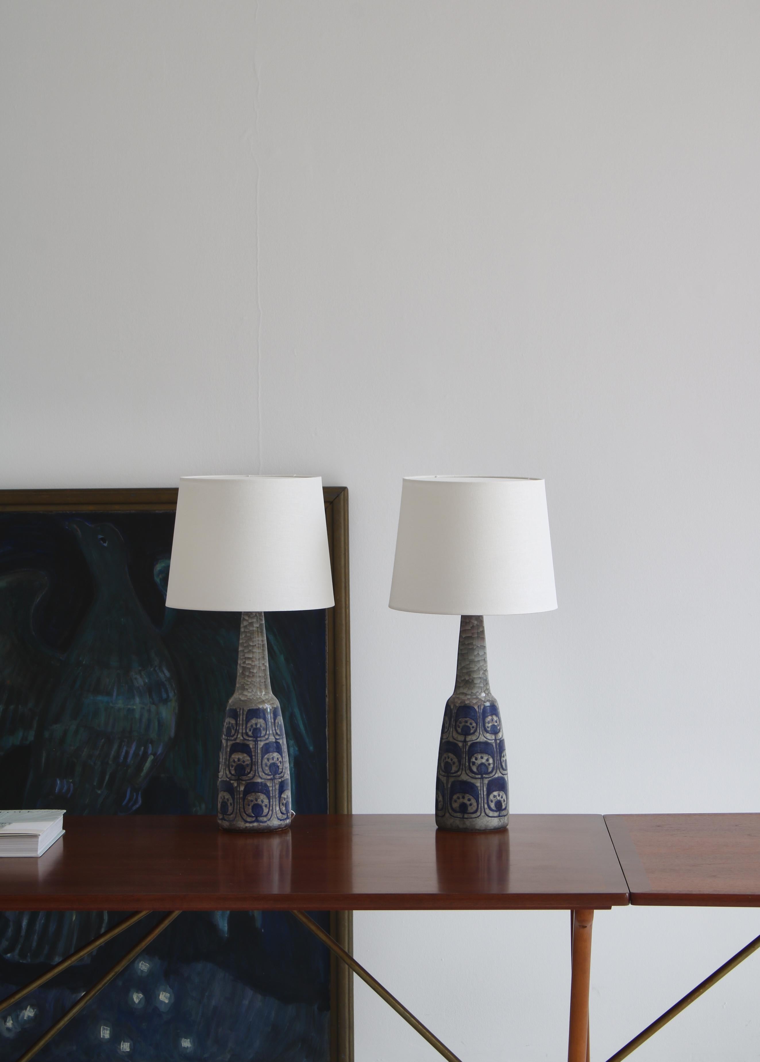 Stunning pair of unique ceramics table lamps made in Denmark in the 1960s at the workshop of Michael Andersen & Son on the small Danish isle of Bornholm. The lamps were designed by artist Marianne Stack and features glossy gray crackle 