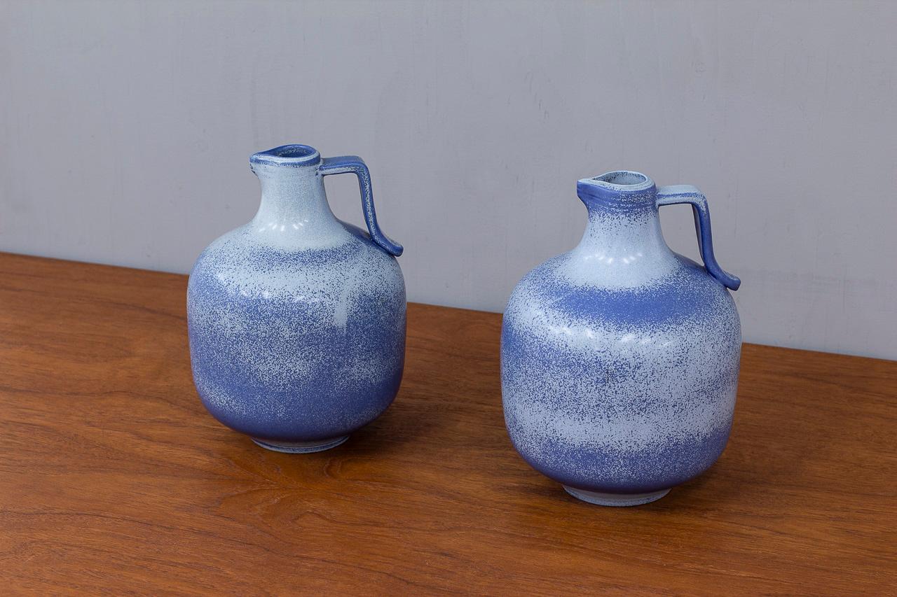 Pair of stoneware vases, pitchers designed by Gunnar Nylund, manufactured at
Rörstrand studio in Sweden during the 1940s. Glazed in two tones of blue with a sprayed method. Both signed, engraved by hand on the bottom.

Gunnar Nylund was artistic