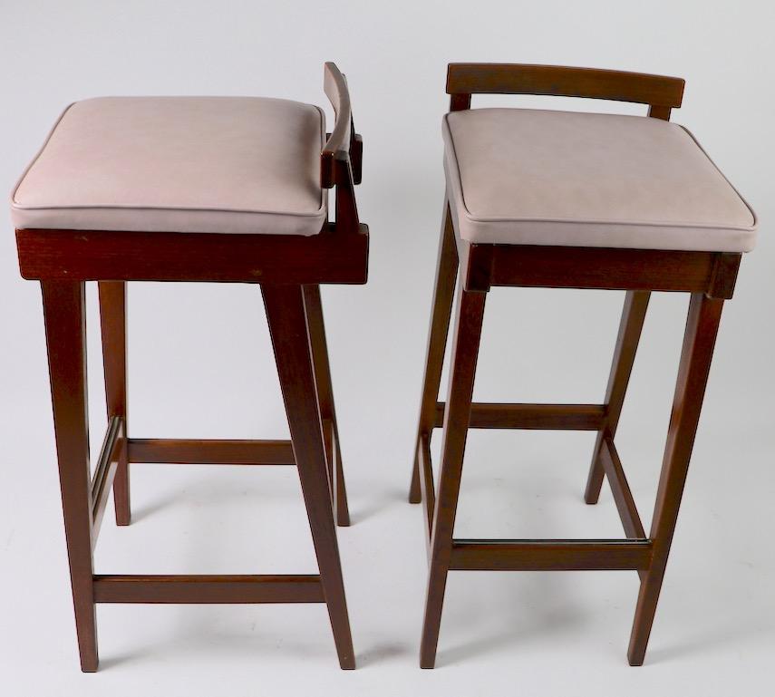 Pair of Danish modern stools designed by Erik Buch for Dyrlund Furniture. These stools are in clean, original condition showing only minor cosmetic wear normal and consistent with age. Constructed of teak and rosewood, with vinyl upholstered pad
