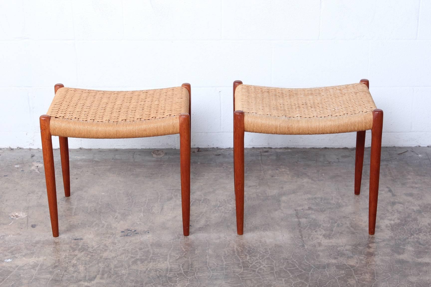 A pair of teak stools with paper cord seats. Designed by Niels O. Møller, manufactured by J.L. Møllers Møbelfabrik.