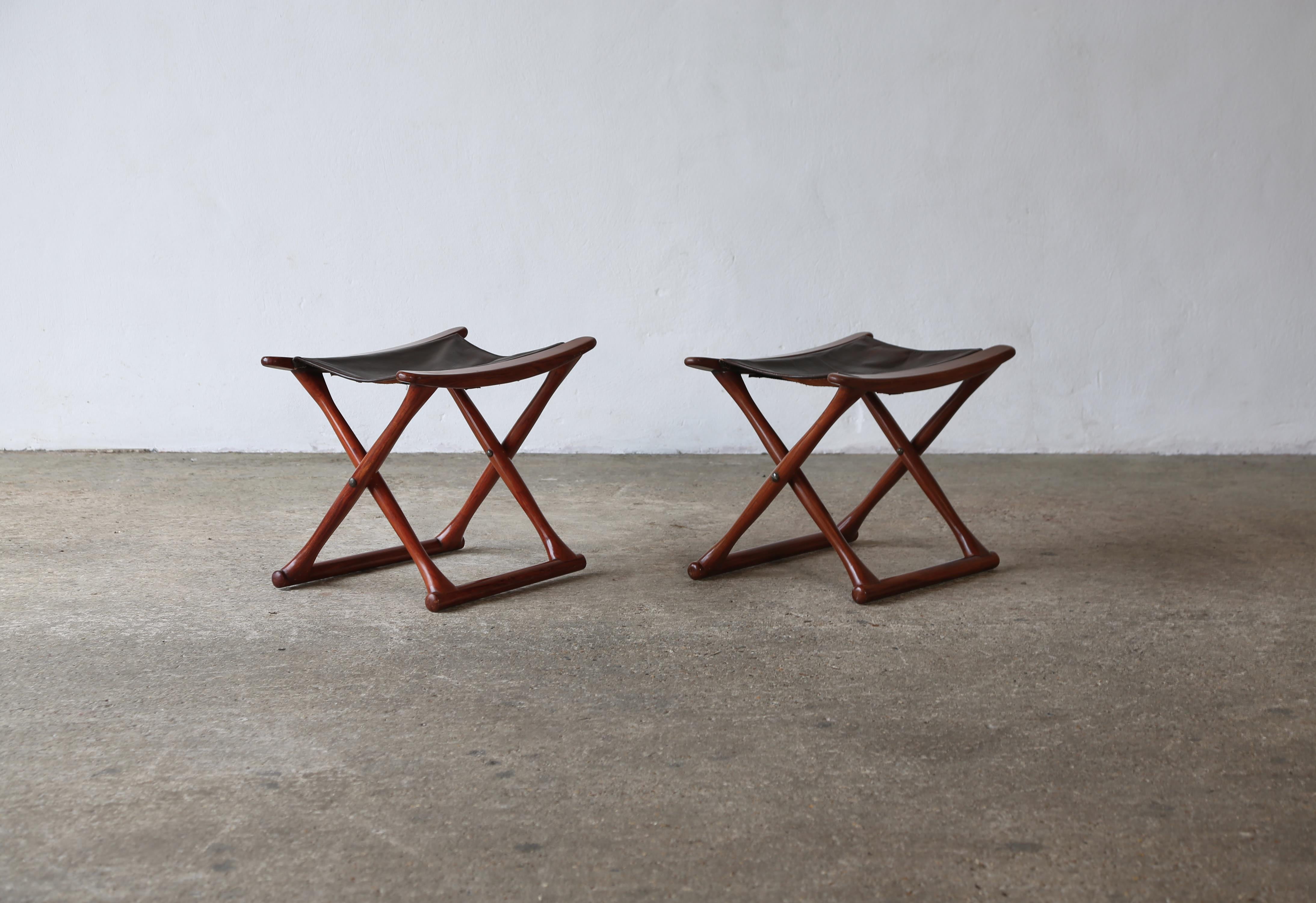 A pair of Danish folding stools, 1960s/70s.   Wood frames and patinated leather seats.