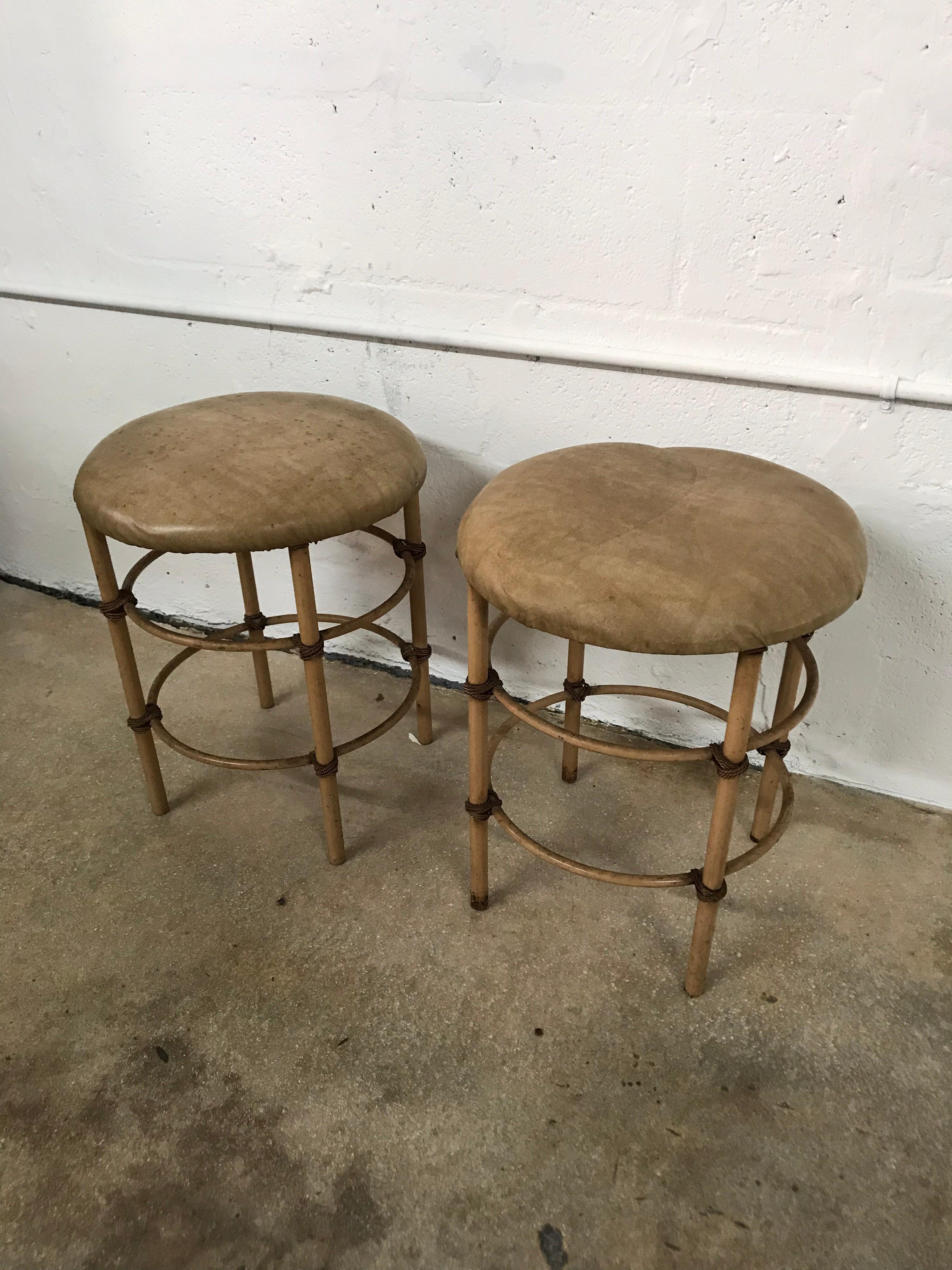 Pair of Hollywood regency midcentury stools rendered in aluminum pipe bound with aluminum rope and vinyl seat, distressed original condition. Can be reupholstered or painted as desired or used as is. USA, Circa 1960s