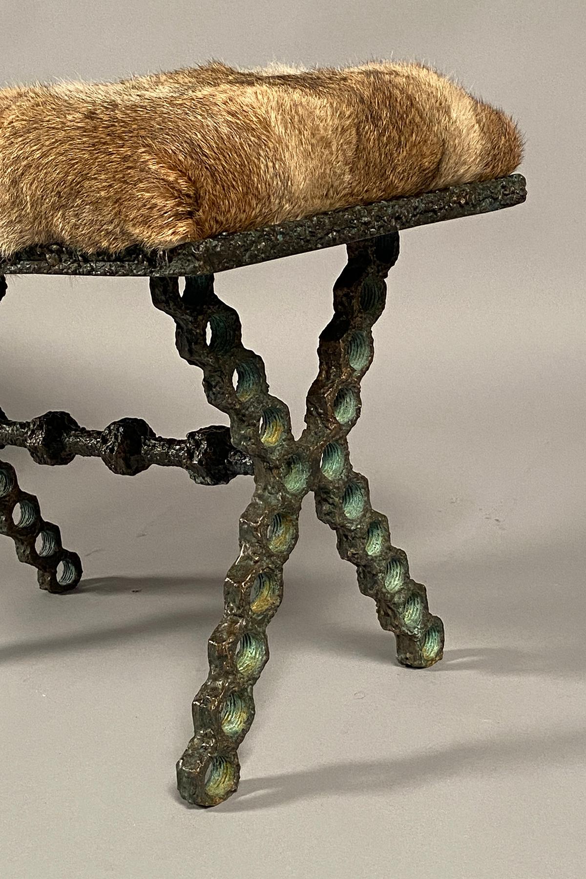 Welded bronze hexagonal elements, an X-form base with a partial verdigris patina, supporting a rectangular seat upholstered in patchwork rabbit fur. Signed and dated on the underside.