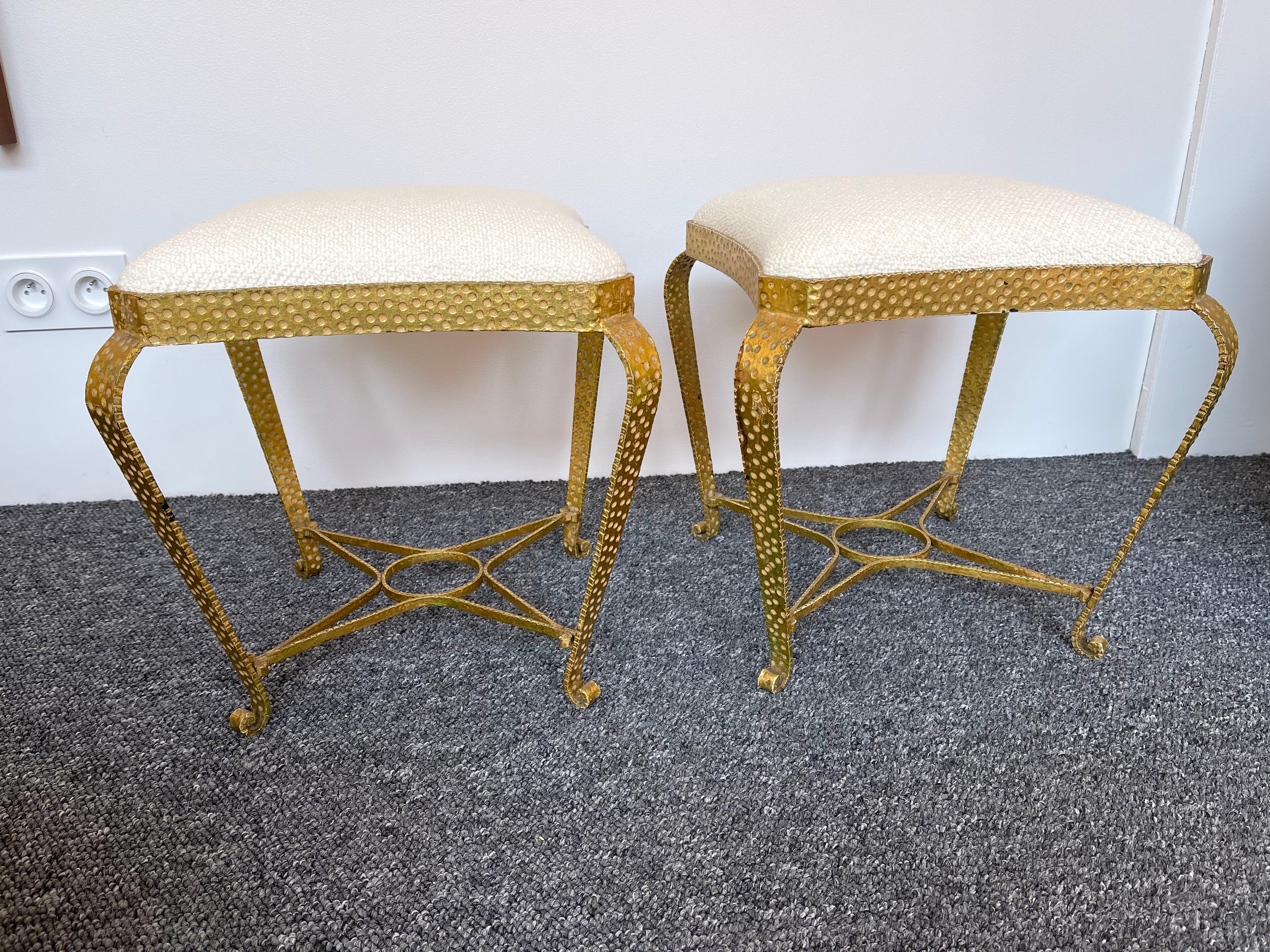 Pair of stools, poufs or ottomans by Pier Luigi Colli. Hammered wrought iron and gold leaf. Fully upholstered in bouclé fabric. A bench are available on my storefront. Famous design like Maison Jansen, Baguès, Gilbert Poillerat, Raymond Subes,