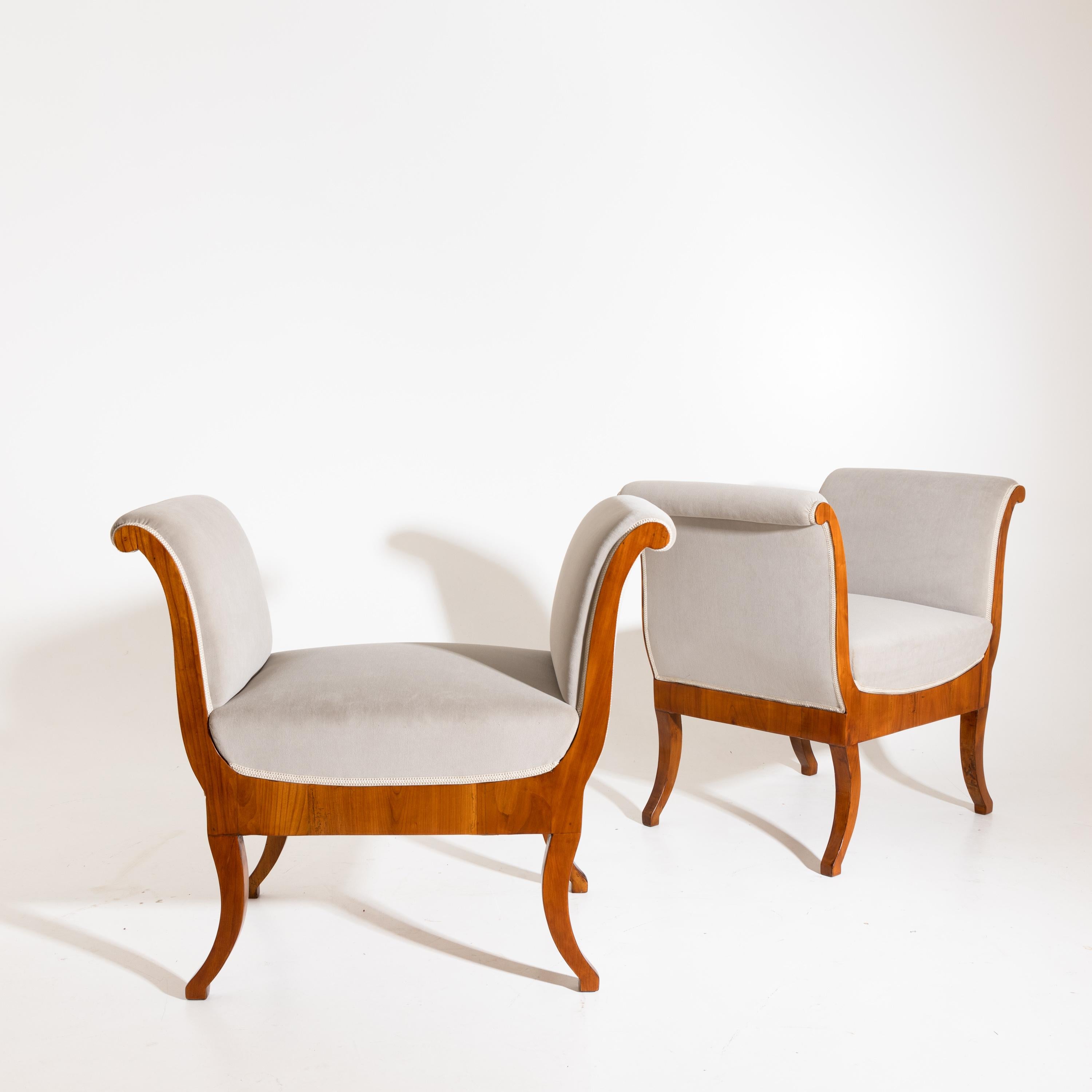 Pair of stools on curved legs with straight front rails and sledge-shaped armrests. Solid and veneered cherry. The stools were covered with a grey velvet fabric and hand-polished.