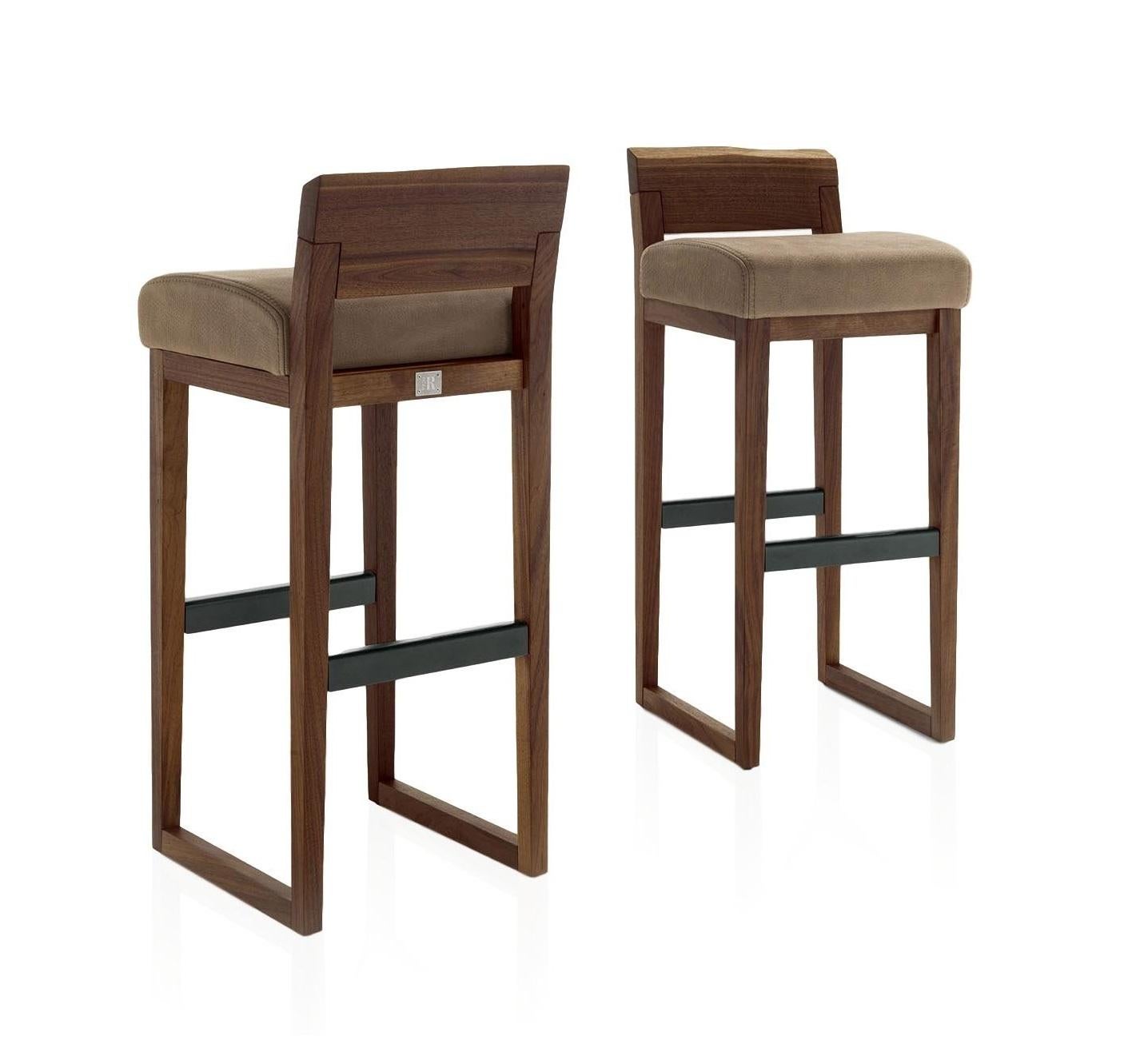 Handcrafted set of 2 bar or counter stools, characterized by a structure in solid American walnut and backrest with a natural edge. Upholstered seat in Italian Utah leather.
Available in two different heights upon request.
Made in Italy and priced