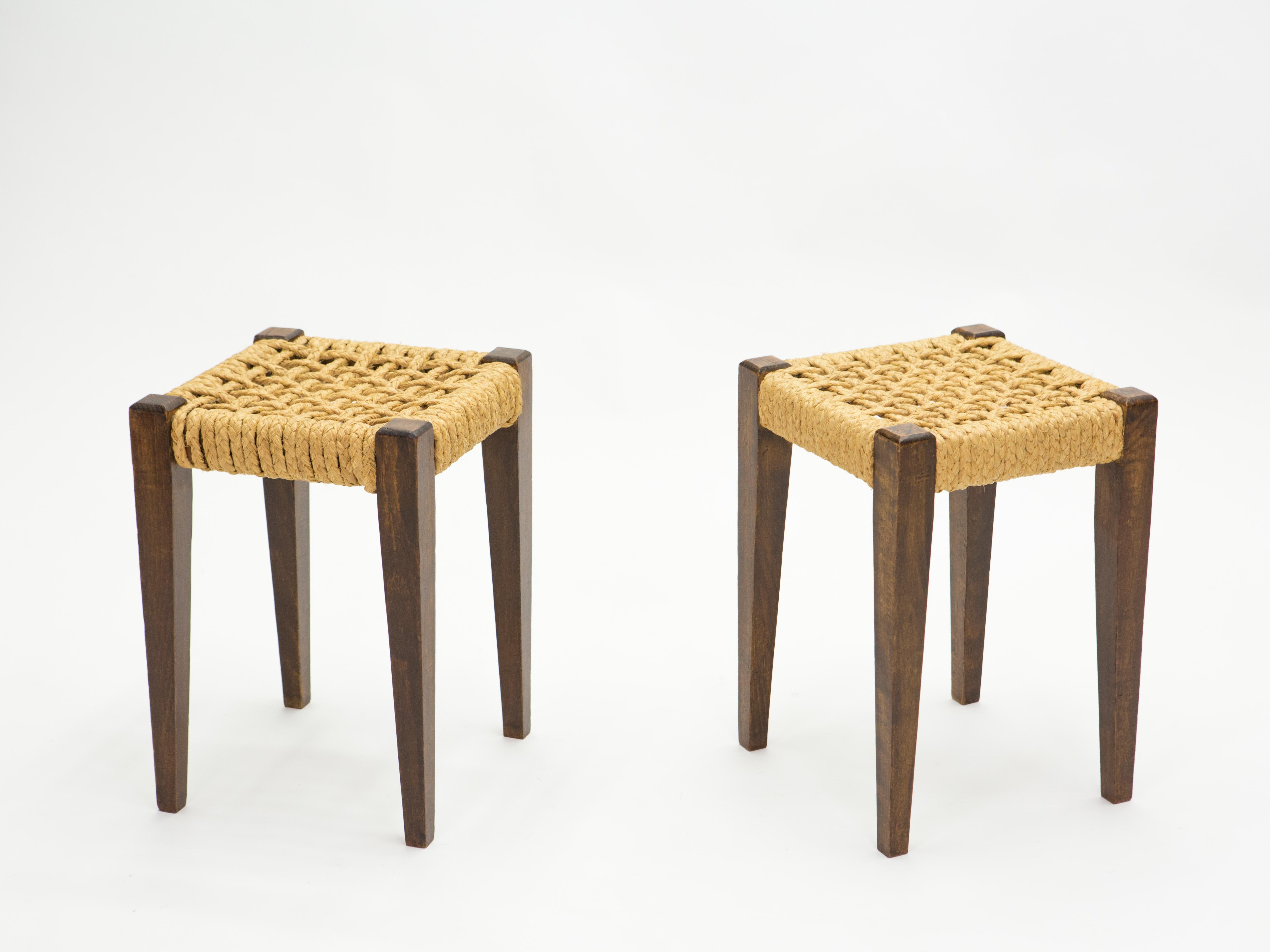 Beautiful patina is evident along the abaca rope seating of this pair of stools by Adrien Audoux et Frida Minet, giving away their vintage status. This natural style is typical of the French design of Audoux-Minet. Timeless Mid-Century Modern design