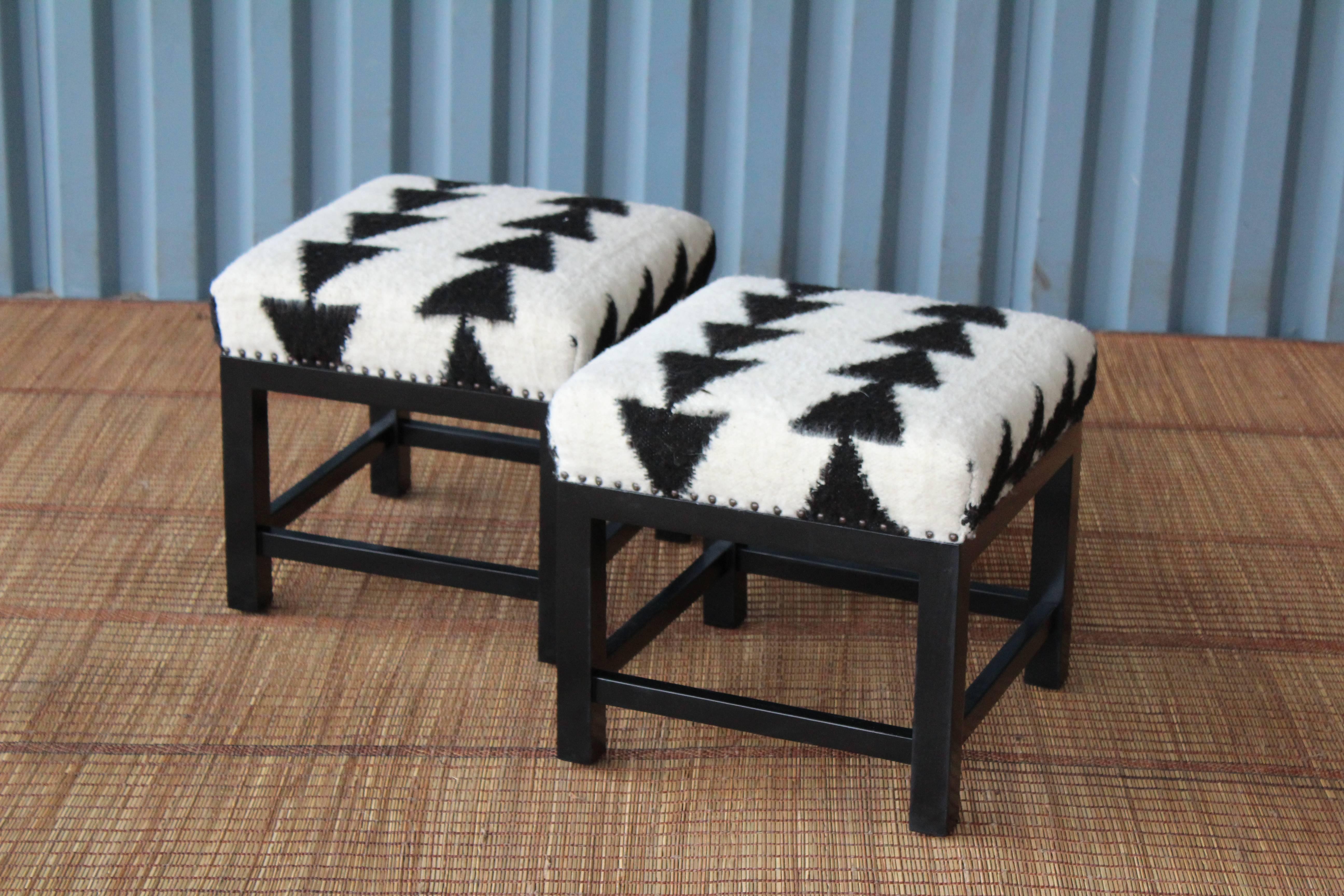 Pair of custom stools by Hollywood at Home. Feature satin black walnut bases with wool upholstery.