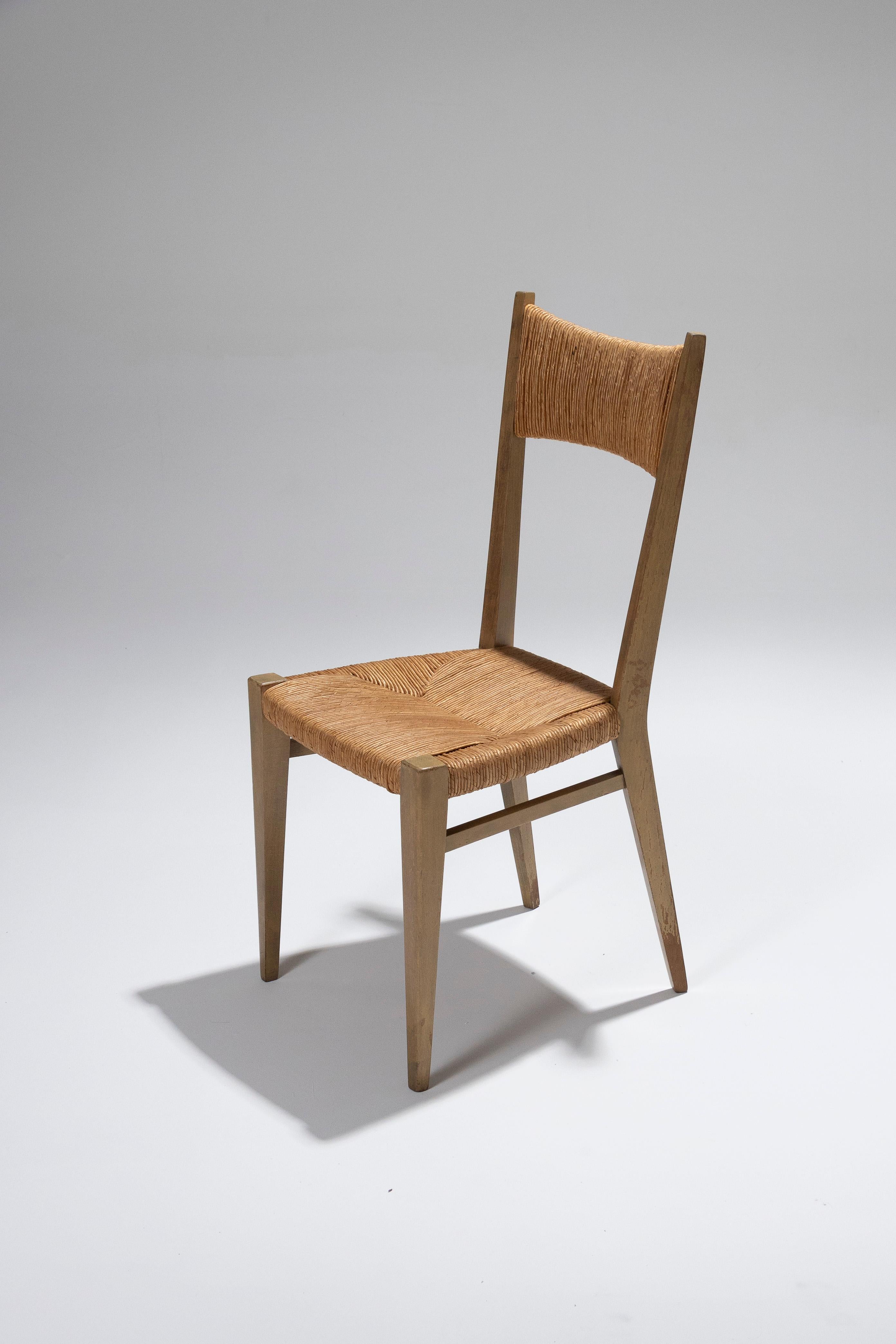 Elegante par de sillas de Geneviève Pons, diseñadas en los años 50, que mezclan influencias escandinavas con encanto rústico. La estructura cónica de roble resalta un asiento y un respaldo de paja tejida, lo que confiere a estas piezas un aspecto