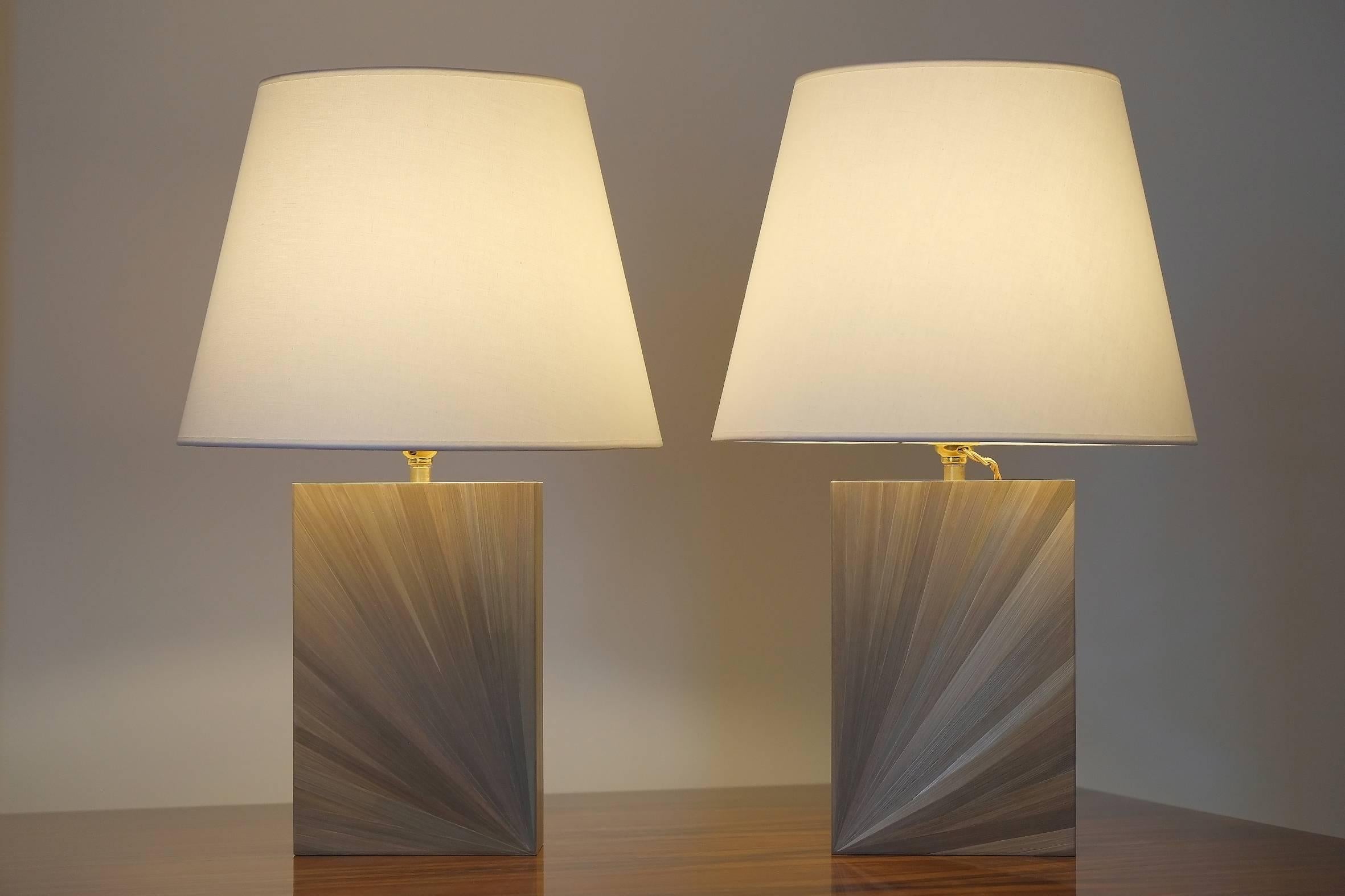 A pair of beautiful bronze coloured straw marquetry table lamps.
Of rectangular shape, the two sides of each lamp decorated with
radiant pattern.
The model illustrated comes with a nice cotton shade.
Other colors and dimensions are possible upon