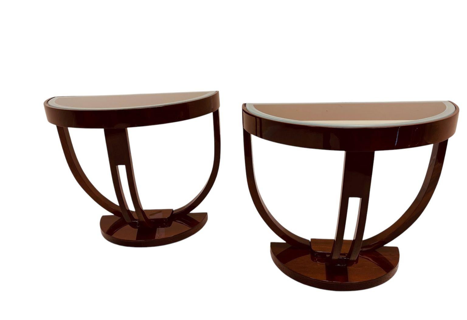 Una splendida coppia di tavolini a semicerchio Streamline Art Deco americani degli anni '30 circa. Tavoli in mogano massiccio tinto acero sapientemente lavorati con un bellissimo bordo del piano in vetro sabbiato. Un esempio elegante e scenografico