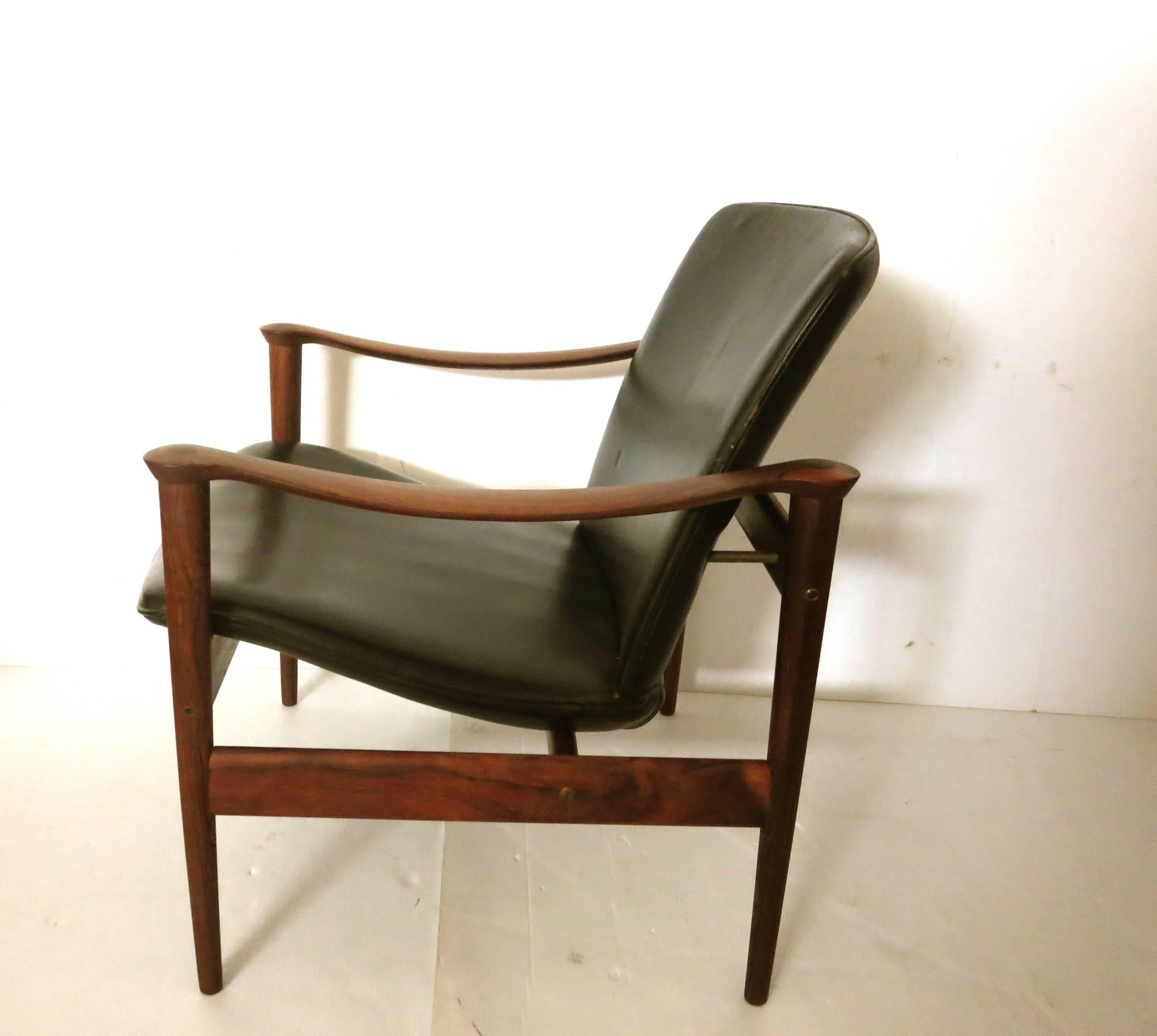 Elegant and unique pair of black leather and rosewood armchairs, designed by Fredrik Kayser, made in Norway the chairs are in great original condition, sculpted armrest, solid and sturdy, loveseat its also available, these chairs are hard to find