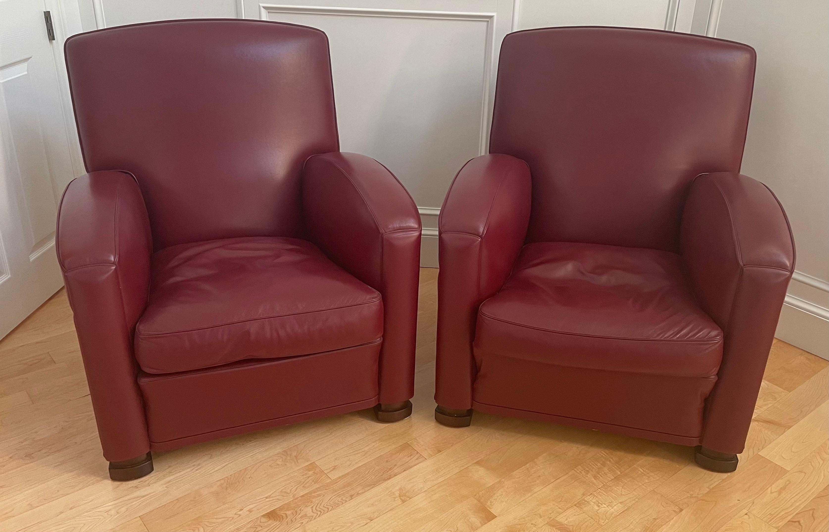 Elegant pair of striking red bordeaux leather arm chairs by Poltrona Frau, circa 2000s. The chairs are in great original condition, incredibly well made and have an Art Deco look. The chairs have a beech wood frame and feet and the padding uses both