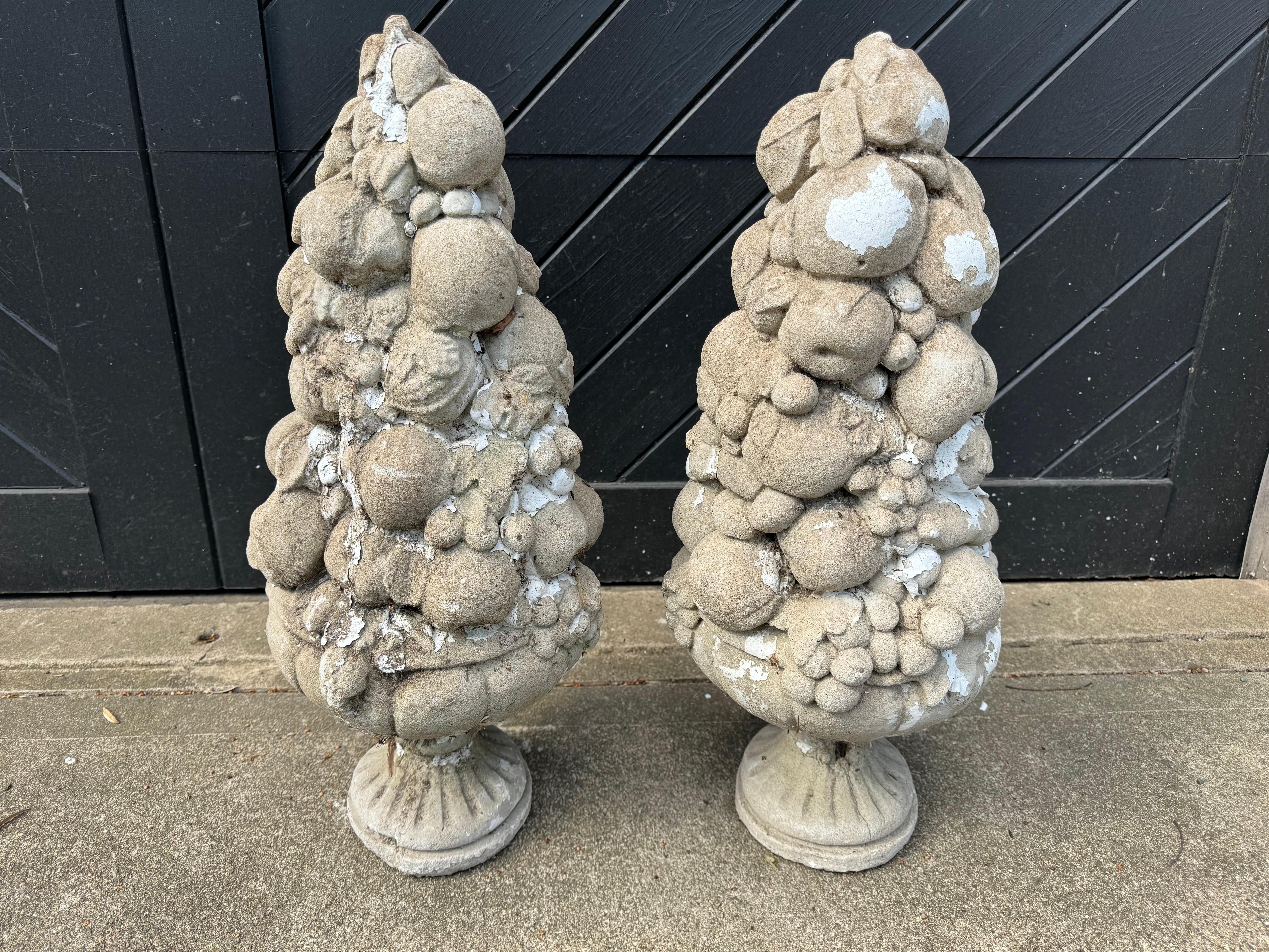 Lovely pair of vintage cement garden ornaments depicting fruit piled high in obelisk forms.  Original vestiges of white paint.