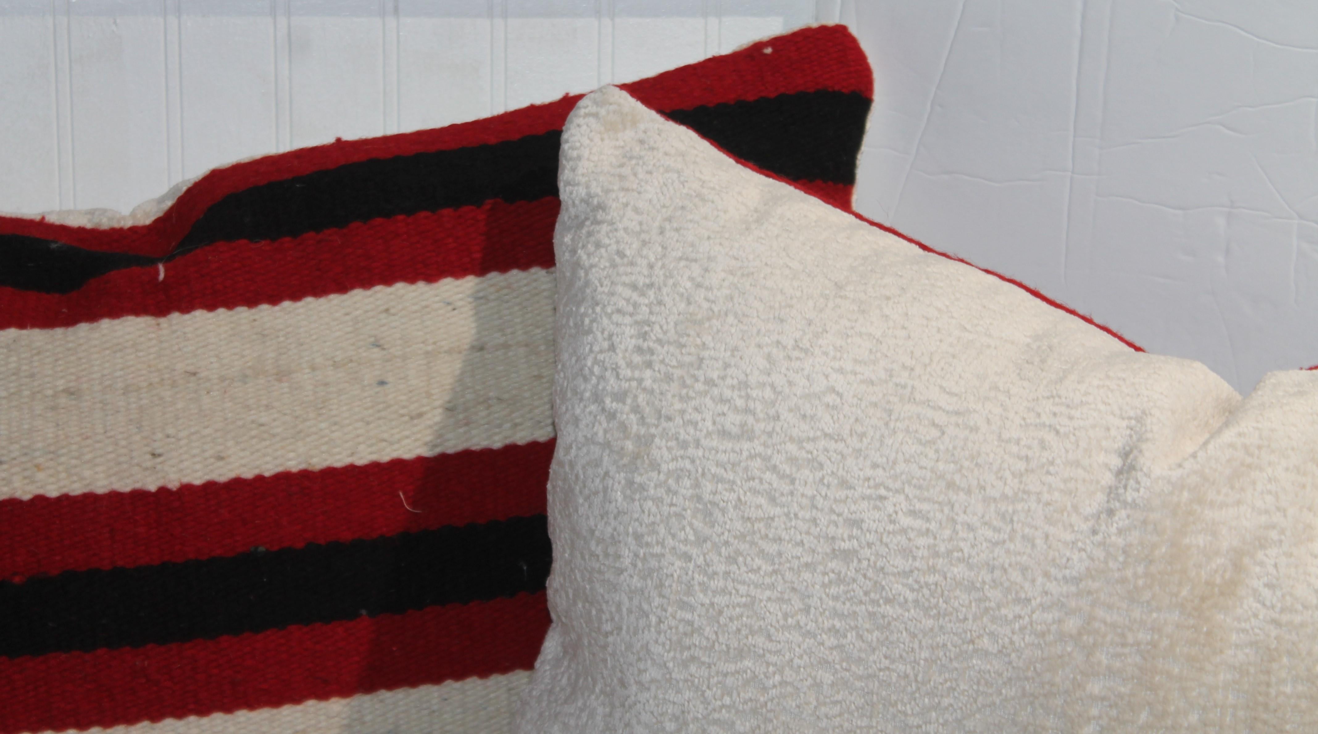 Pair of Striped Navajo Weaving Pillows with Checker Corner Pattern. Deep red and blacks stripes provide a deep color contrast. The white background allows for the red and black colors to pop  on this pillow. We have placed a white linen backing on