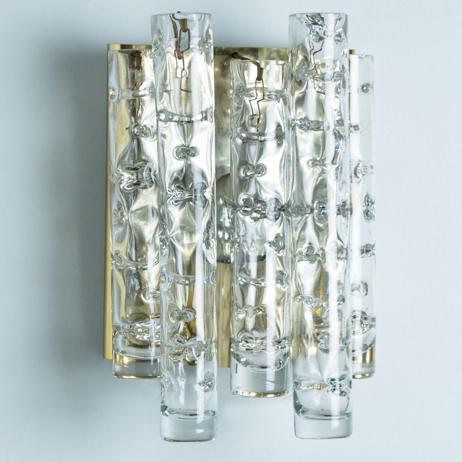 Wonderful hand blown Doria wall lamps. Manufactured in the 1960s. With textured and clear and gold structured glass pipes.
The stylish elegance of this lamp suits many environments, from mid century to Hollywood Regency, from Danish modern to Space