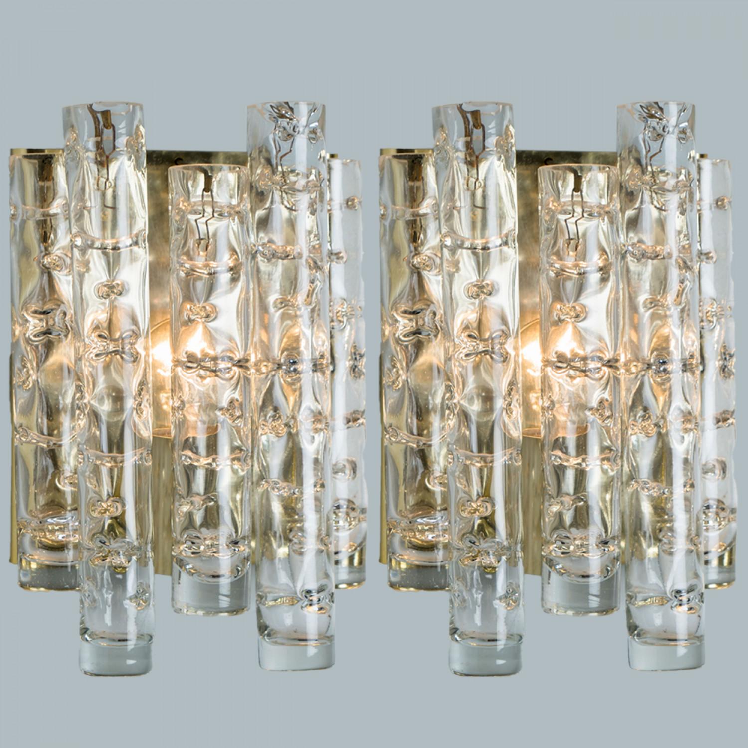Merveilleuses appliques Doria soufflées à la main. Fabriqué dans les années 1960. Avec des tuyaux en verre texturé, transparent et structuré en or.
L'élégance de cette lampe convient à de nombreux environnements, du milieu du siècle à Hollywood