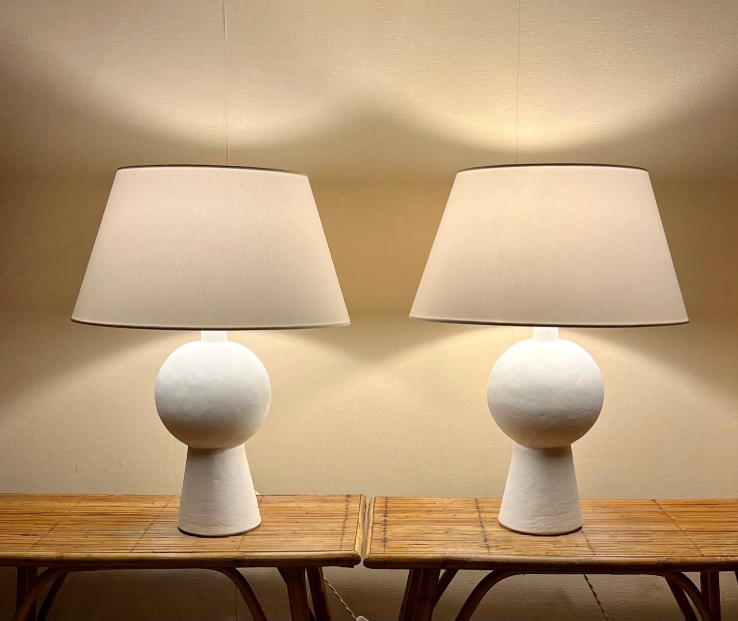 Pair of stuccoed plaster lamps
The finish of the plasterwork is slightly textured (see detail pictures) 
With fabric custom made shades.
France, modern production
Model: Orbis
Simple minimalist design inspired by  Alberto Giacometti mid-century