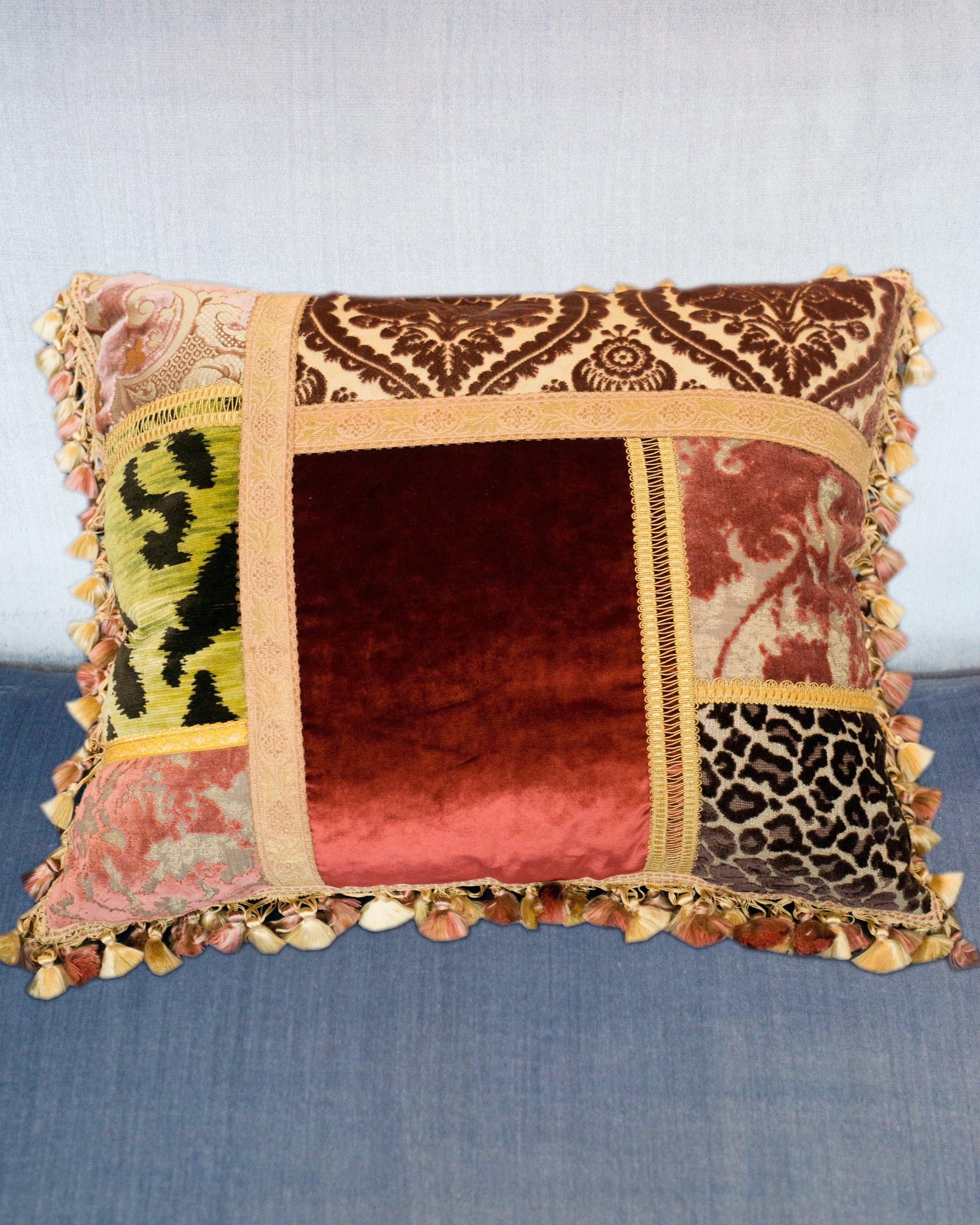 A Studio Maison Nurita patchwork pillow with a variety of luxurious silk and cut pile velvets and metallic trims with bullion fringe backed in red silk velvet, down filled.